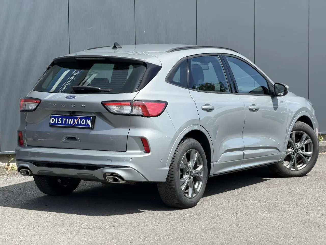 Vue 3/4 arrière droite d’un Ford Kuga 2.0 EcoBlue gris Solar avec double sortie d’échappement et jantes alliage 18 pouces.