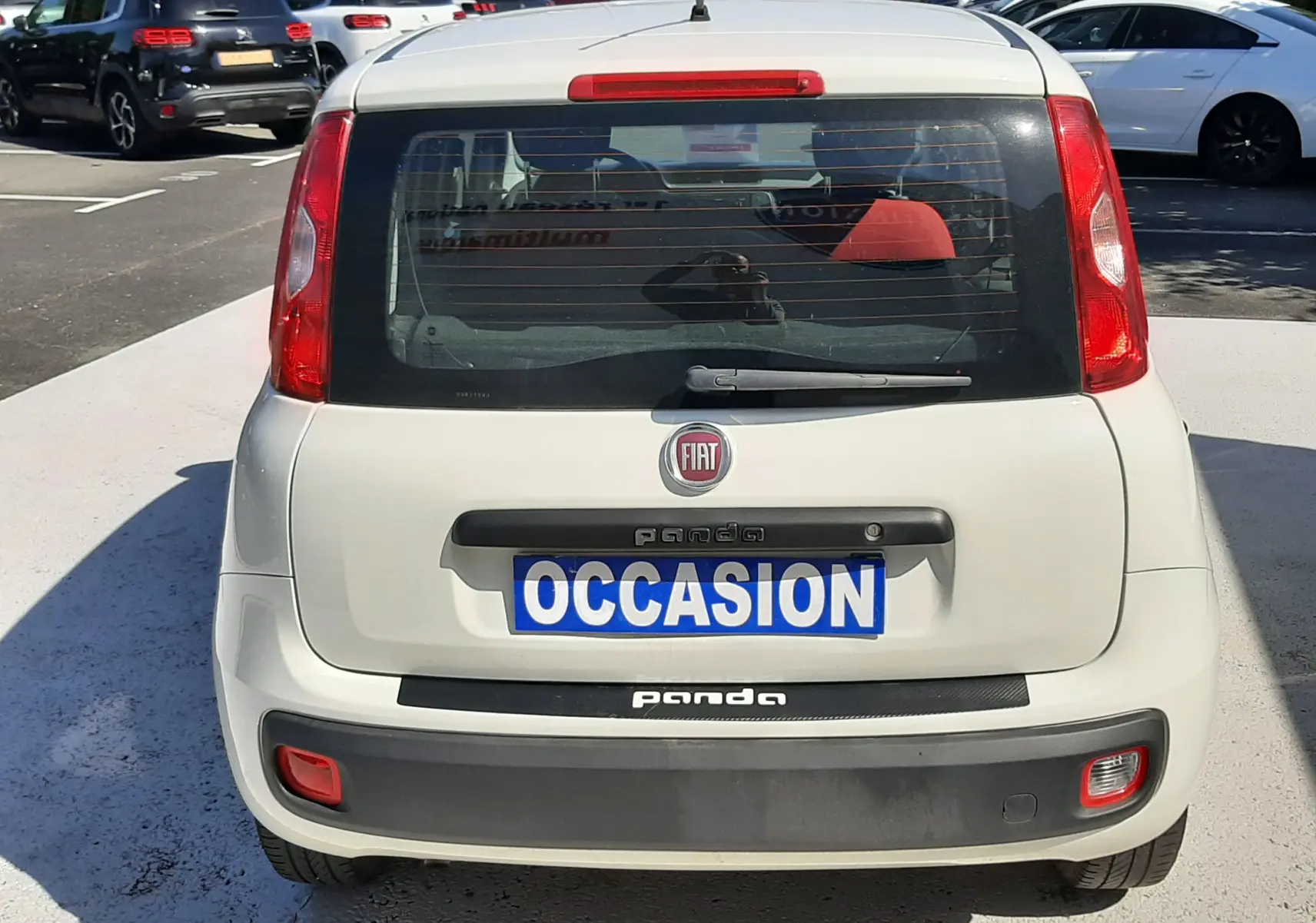 Vue 3/4 arrière droite d'une Fiat Panda blanche 2018 avec cinq portes, feux arrière rouges et plaque "OCCASION".