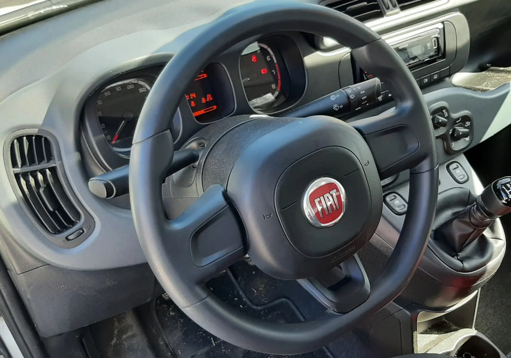 Vue 3/4 arrière droite d'une Fiat Panda blanche 2018 avec plaque "OCCASION" sur un parking extérieur.