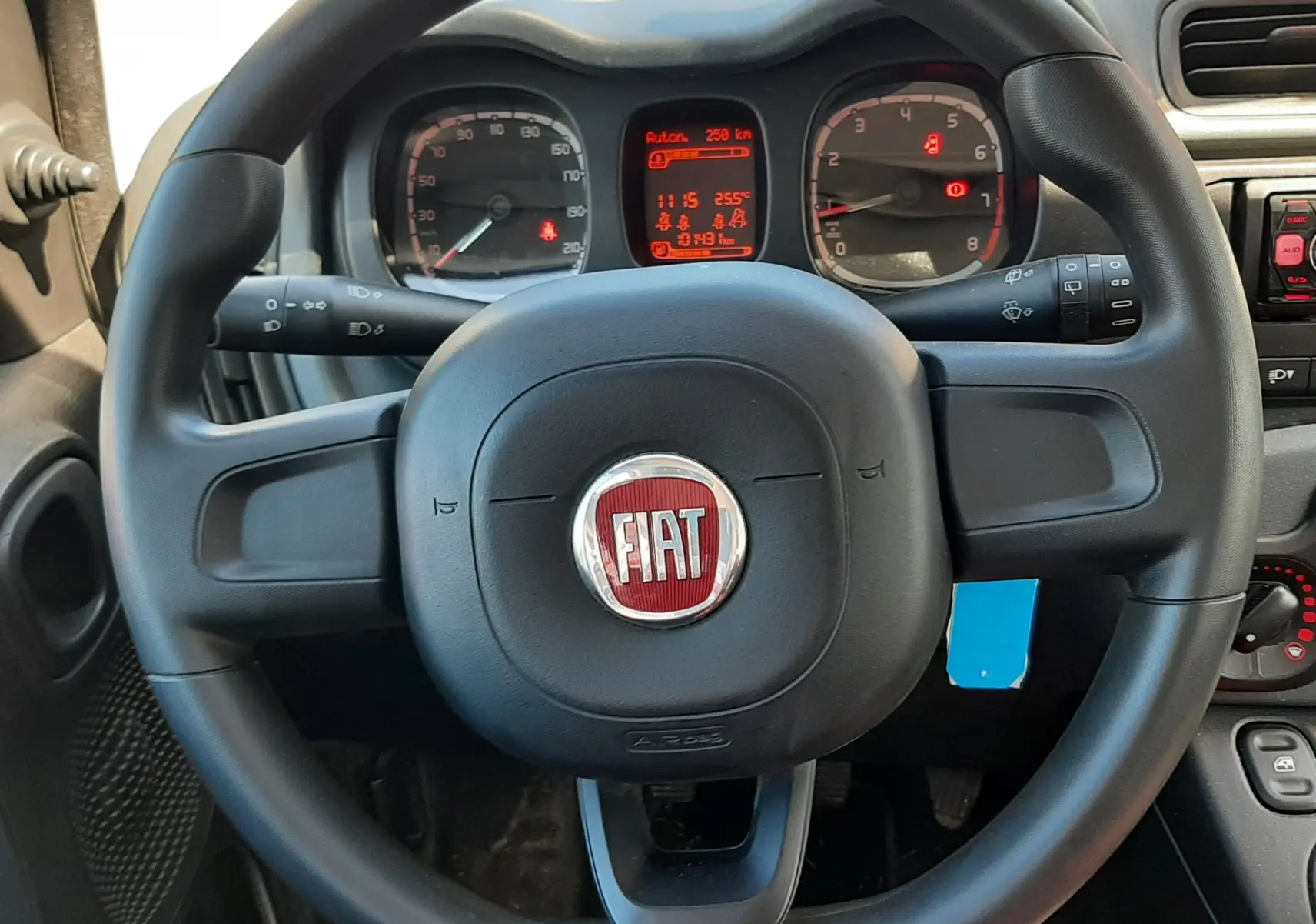 Vue intérieure centrée sur le volant noir de la Fiat Panda 1.2 69CH POP 2018 avec tableau de bord et commandes visibles.