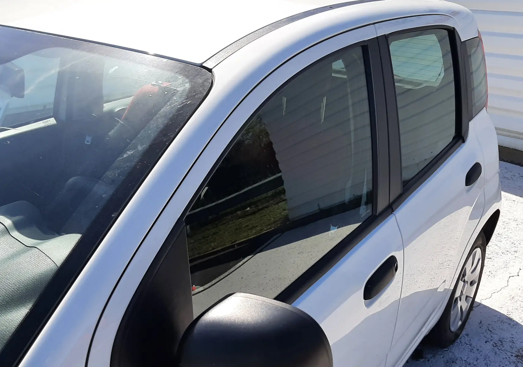 Profil côté gauche d'une FIAT Panda blanche 2018 à cinq portes, avec rétroviseurs noirs et jantes simples.