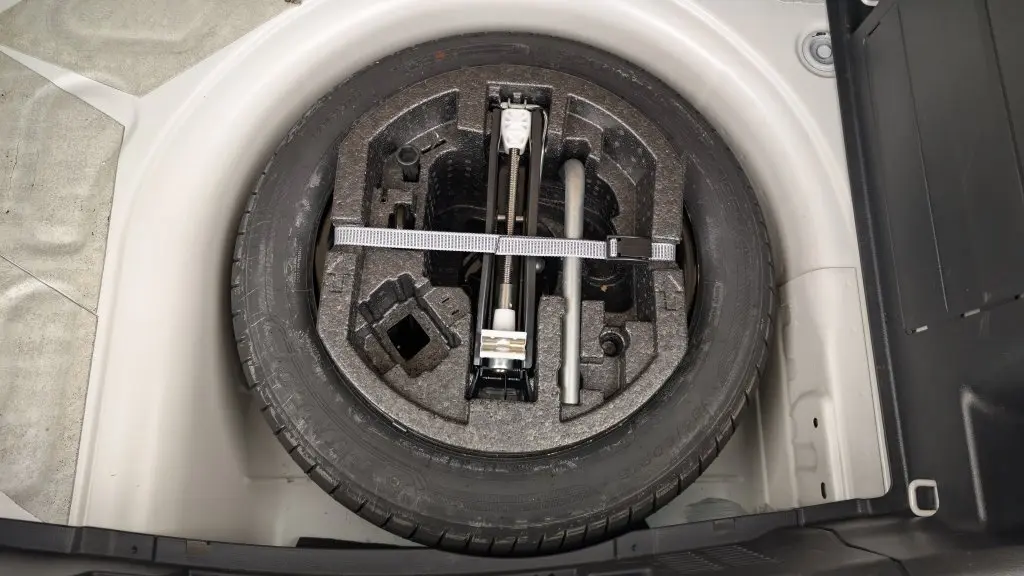 Roue de secours noire avec outillage intégré dans le coffre blanc cristallin d'une Skoda Fabia 2020 essence.