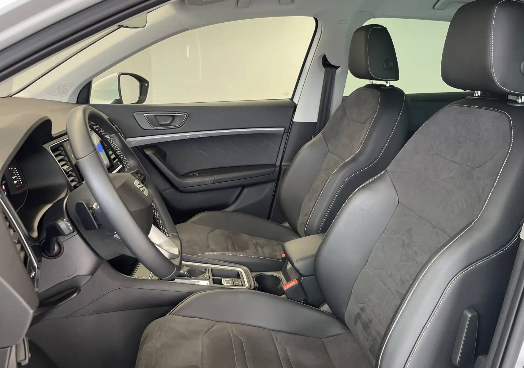 Intérieur avant du SEAT Ateca blanc Nevada 2024, sièges en cuir et alcantara avec surpiqûres contrastées.