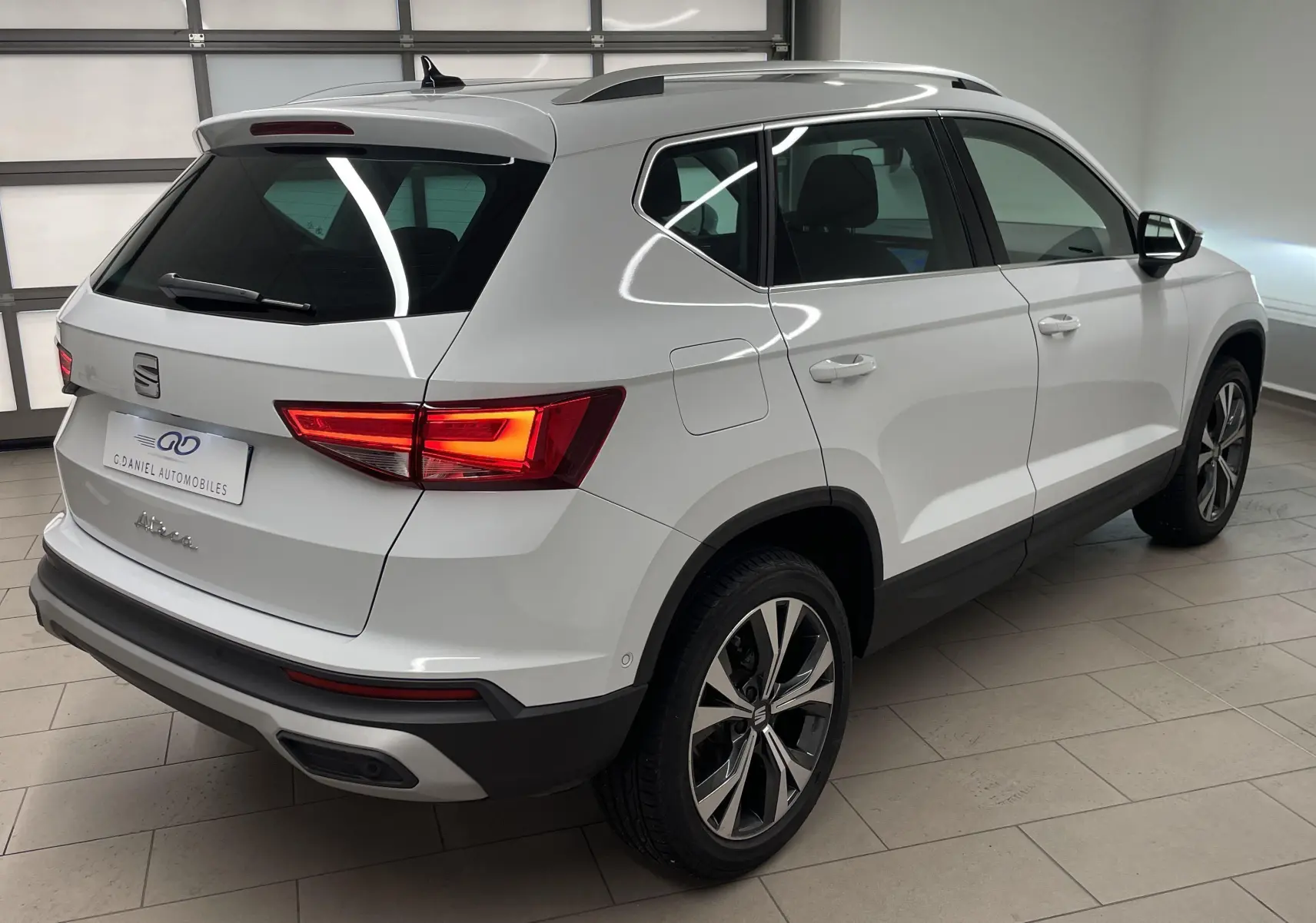 Vue 3/4 arrière droite du SEAT Ateca blanc Nevada avec jantes alliage 18 pouces et hayon électrique mains libres.
