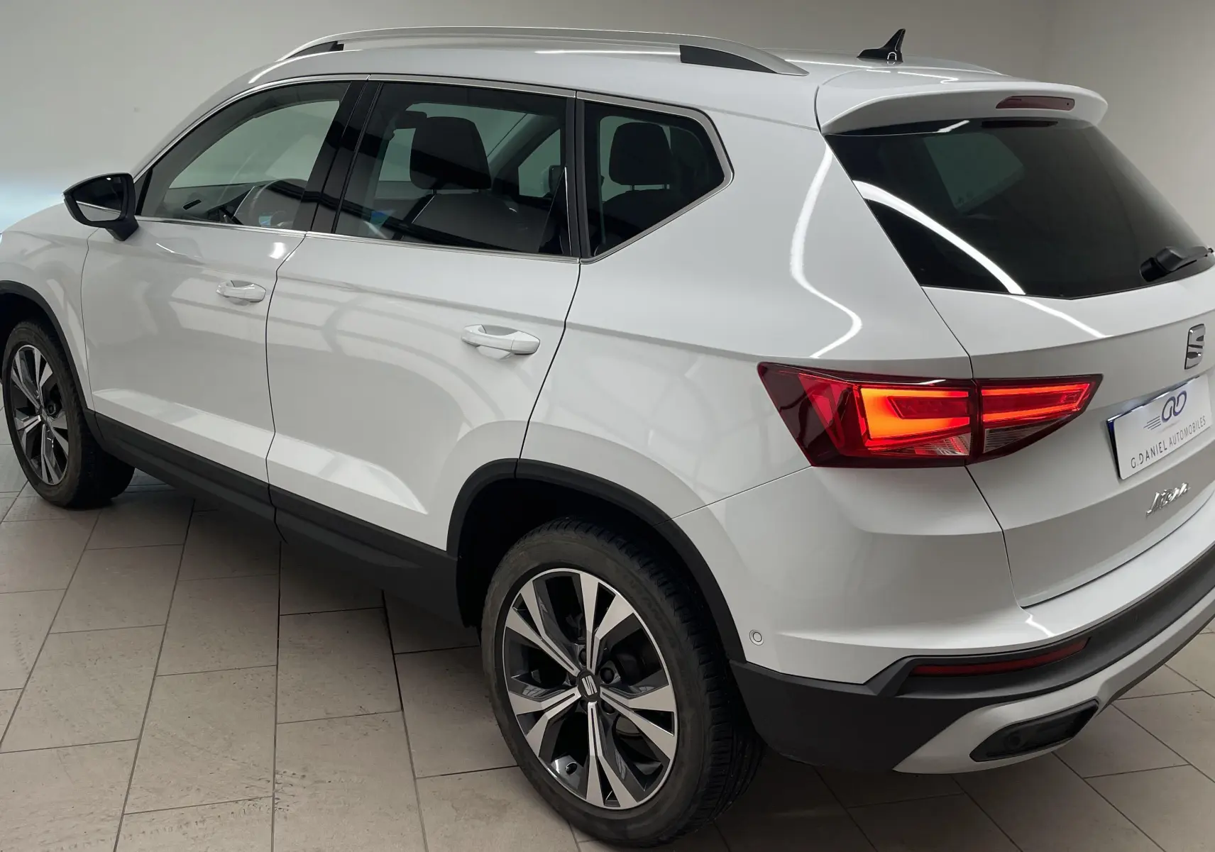 SEAT Ateca blanc Nevada vu en 3/4 arrière droit, avec jantes alliage 18'' et hayon électrique mains libres.