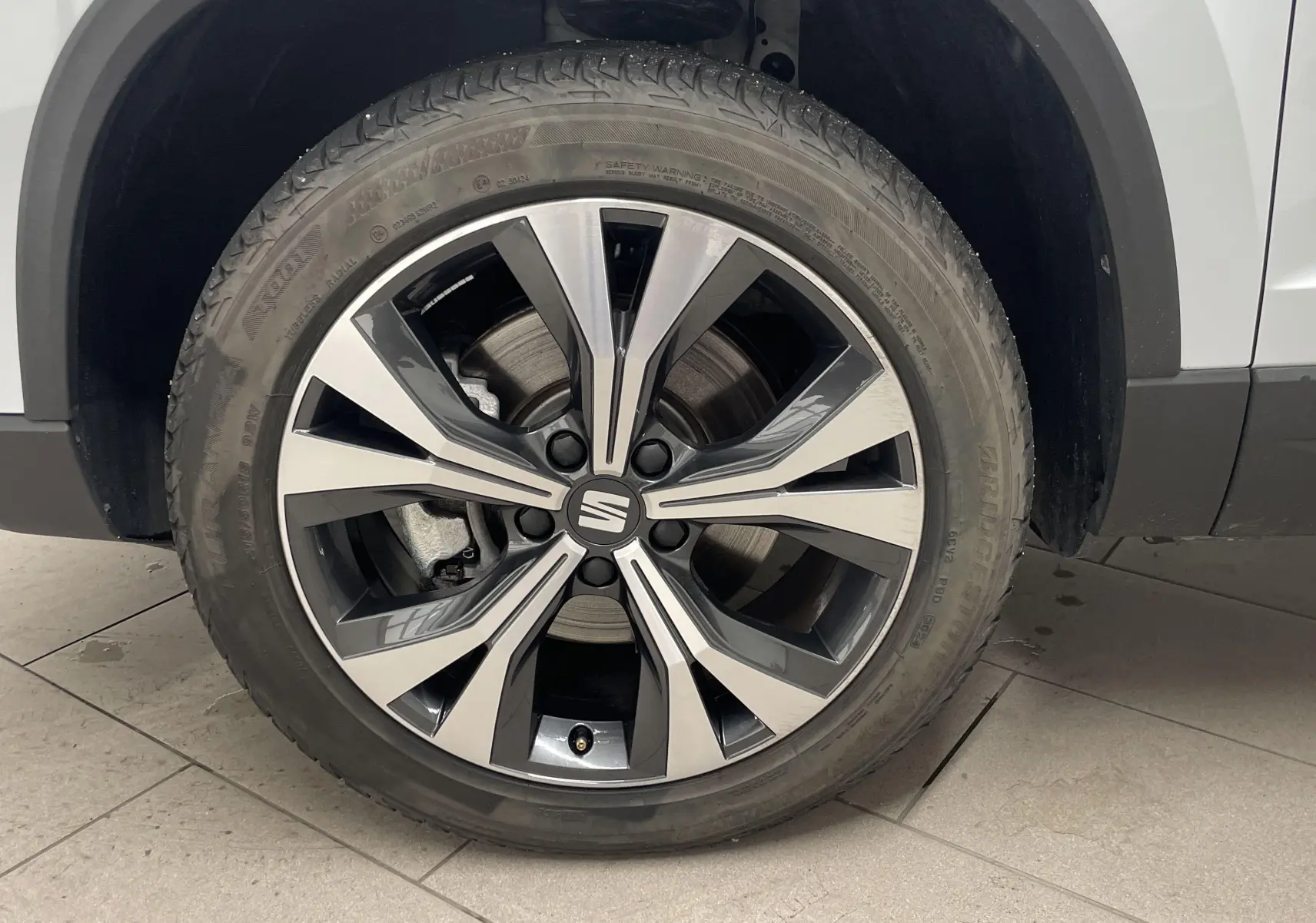 Gros plan sur la jante alliage 18'' usinée côté avant droit du SEAT Ateca blanc Nevada 2024