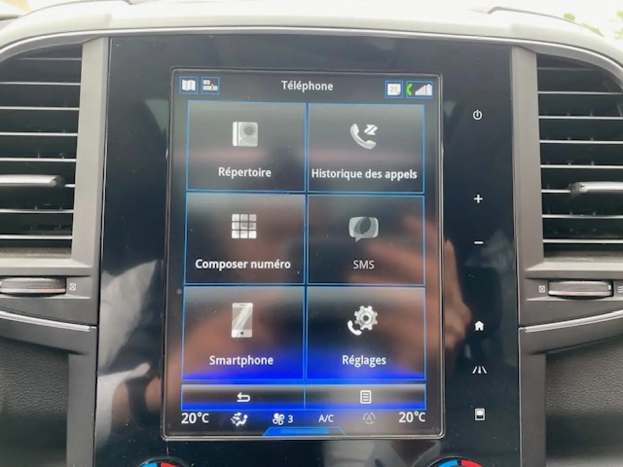 Écran tactile central du Renault Koleos blanc 2019, affichant le menu téléphone avec options de communication.