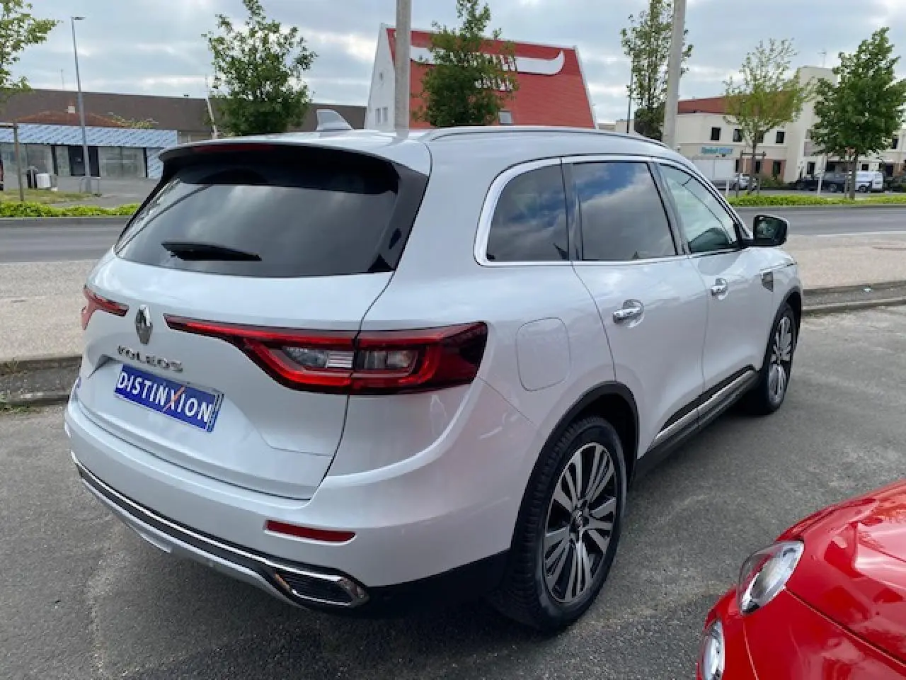 Renault Koleos blanc vu en 3/4 arrière droit, avec vitres teintées et feux arrière LED distinctifs.