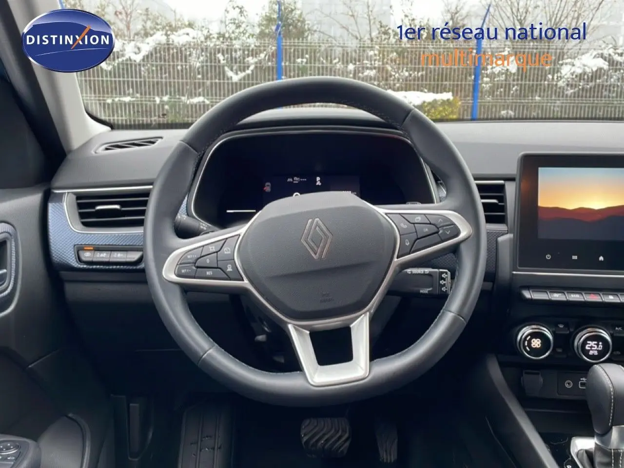 Vue centrée sur le volant cuir noir du Renault Arkana 2025, avec tableau de bord digital et écran tactile visible.