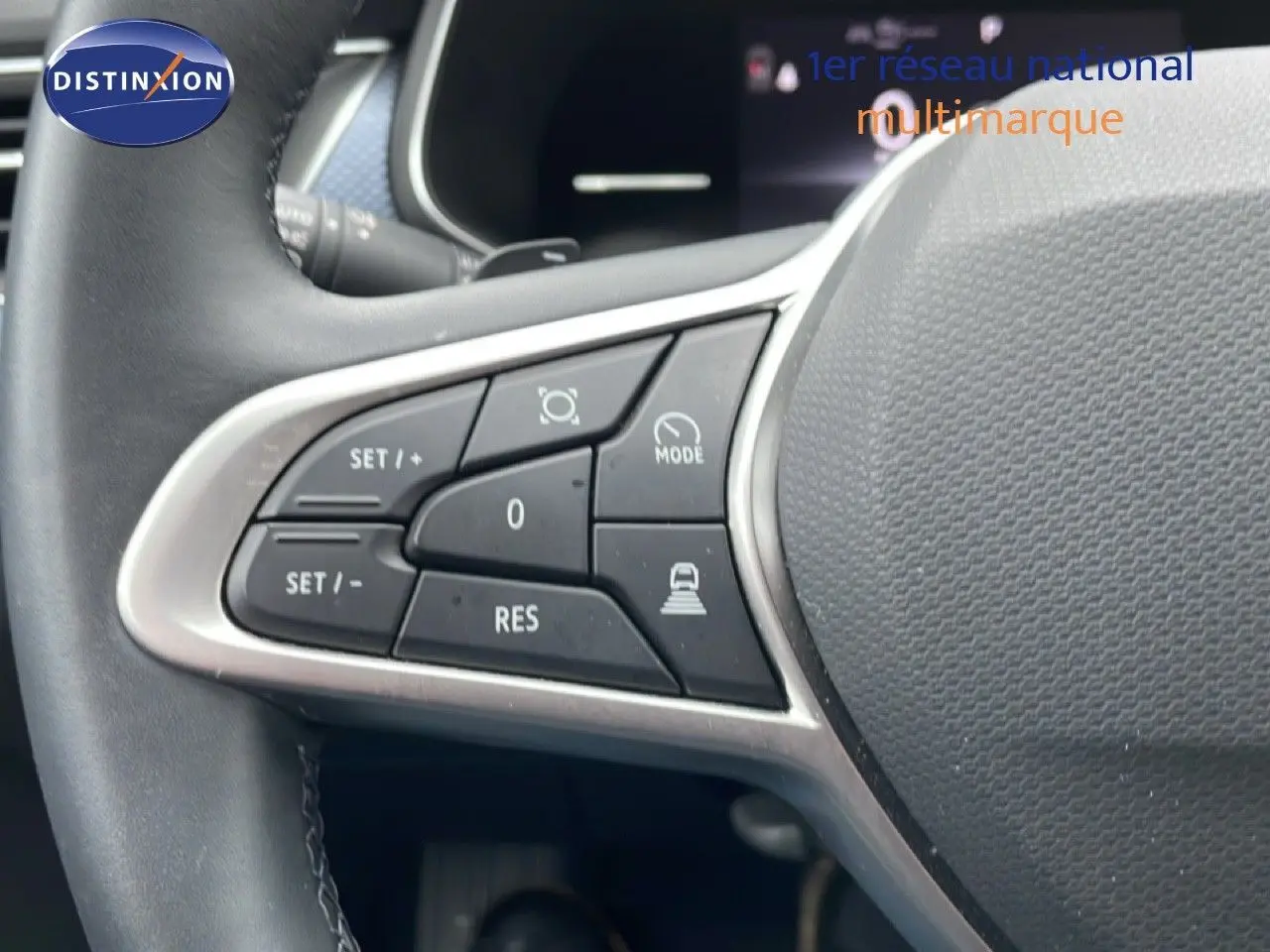 Gros plan sur les commandes de régulateur de vitesse au volant d’un Renault Arkana 2025 bleu Zanzibar métal.