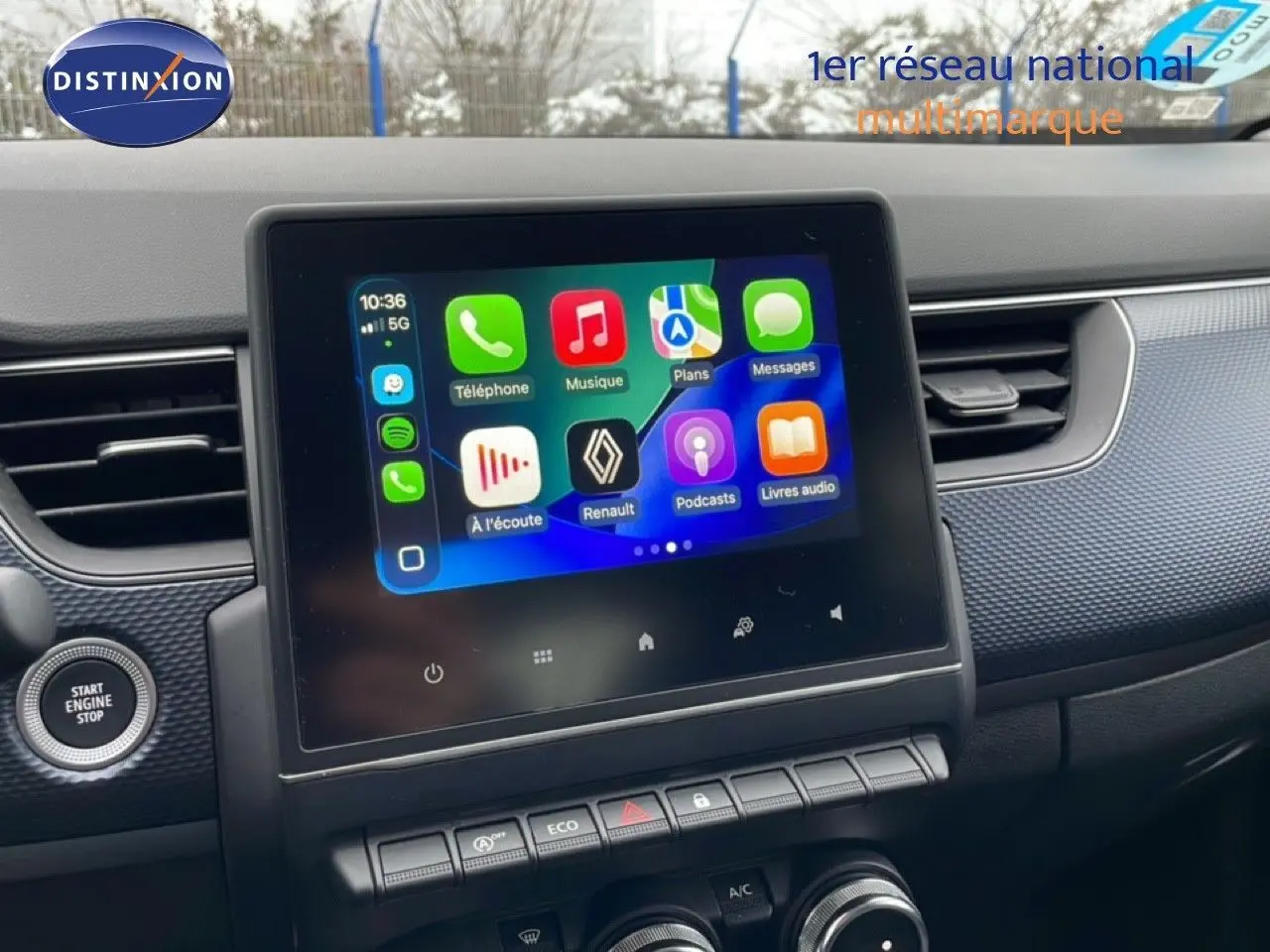 Écran tactile central affichant l'interface multimédia Apple CarPlay dans le tableau de bord noir du Renault Arkana.