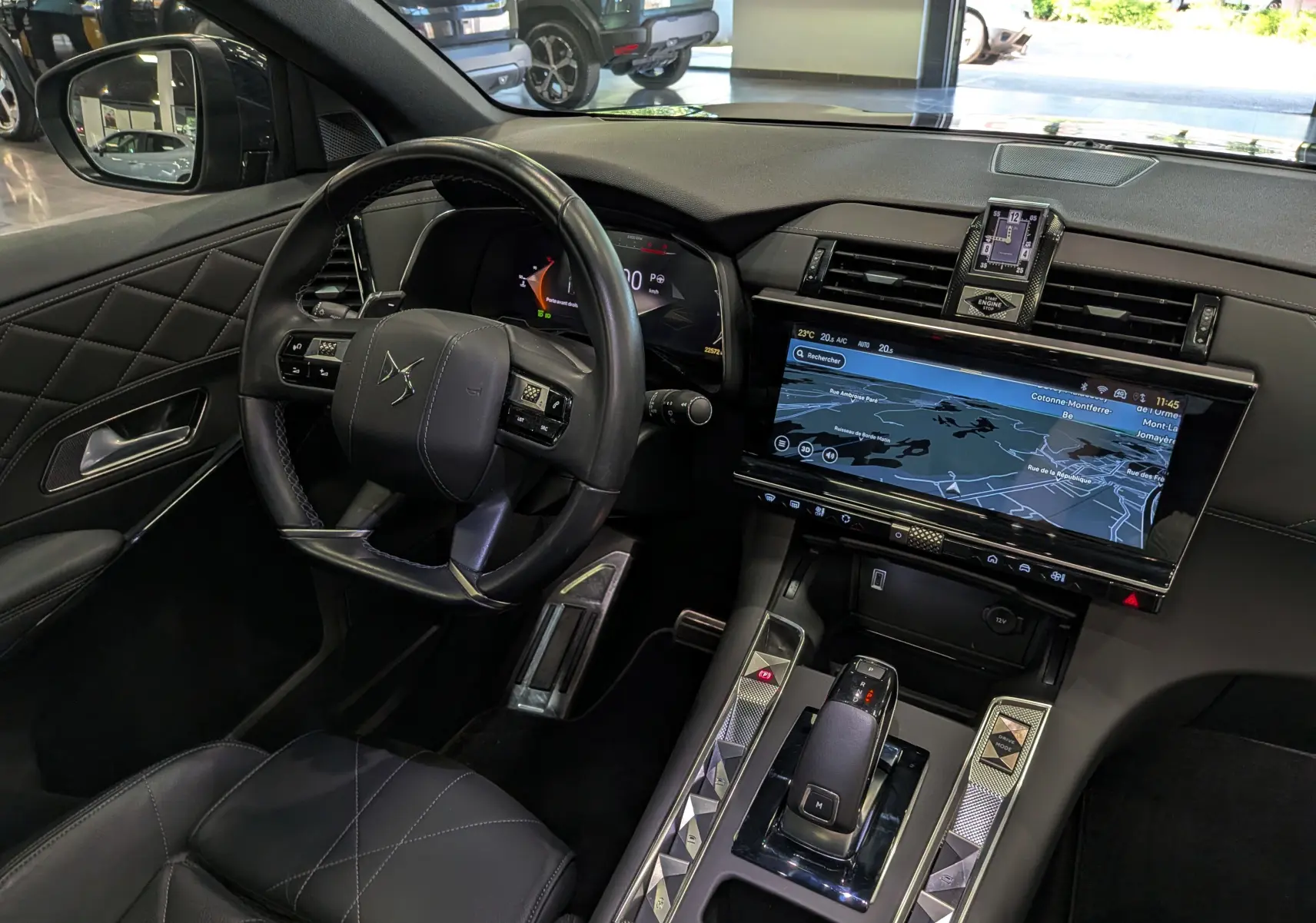 Vue intérieure côté conducteur du DS7 2024 gris, mettant en valeur le volant cuir, l'écran tactile et la console centrale moderne.