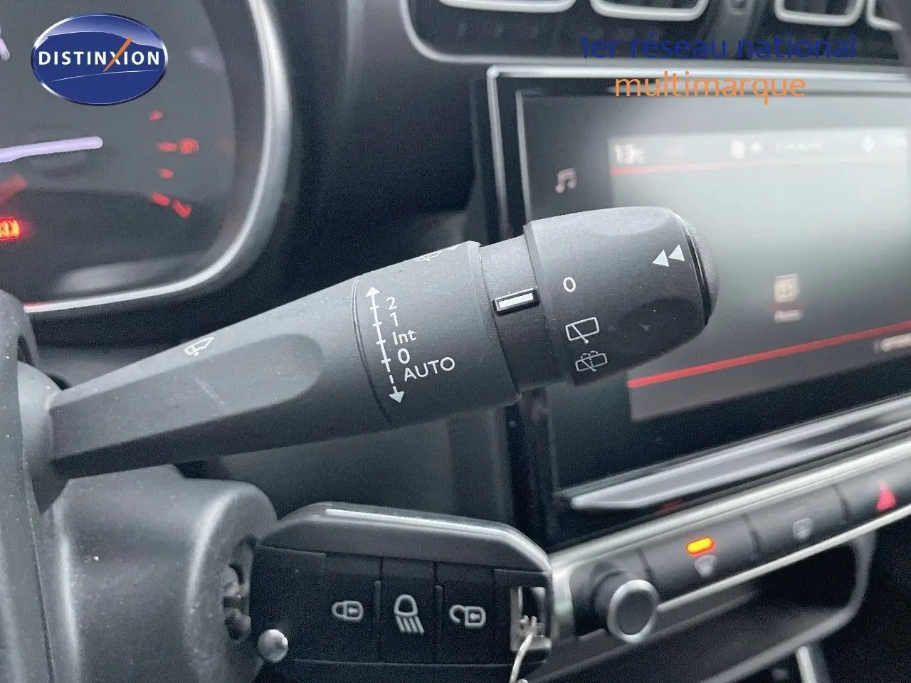 Gros plan sur la commande d'essuie-glace à gauche du volant dans l'habitacle du Citroën C3 Aircross gris platinium 2023.