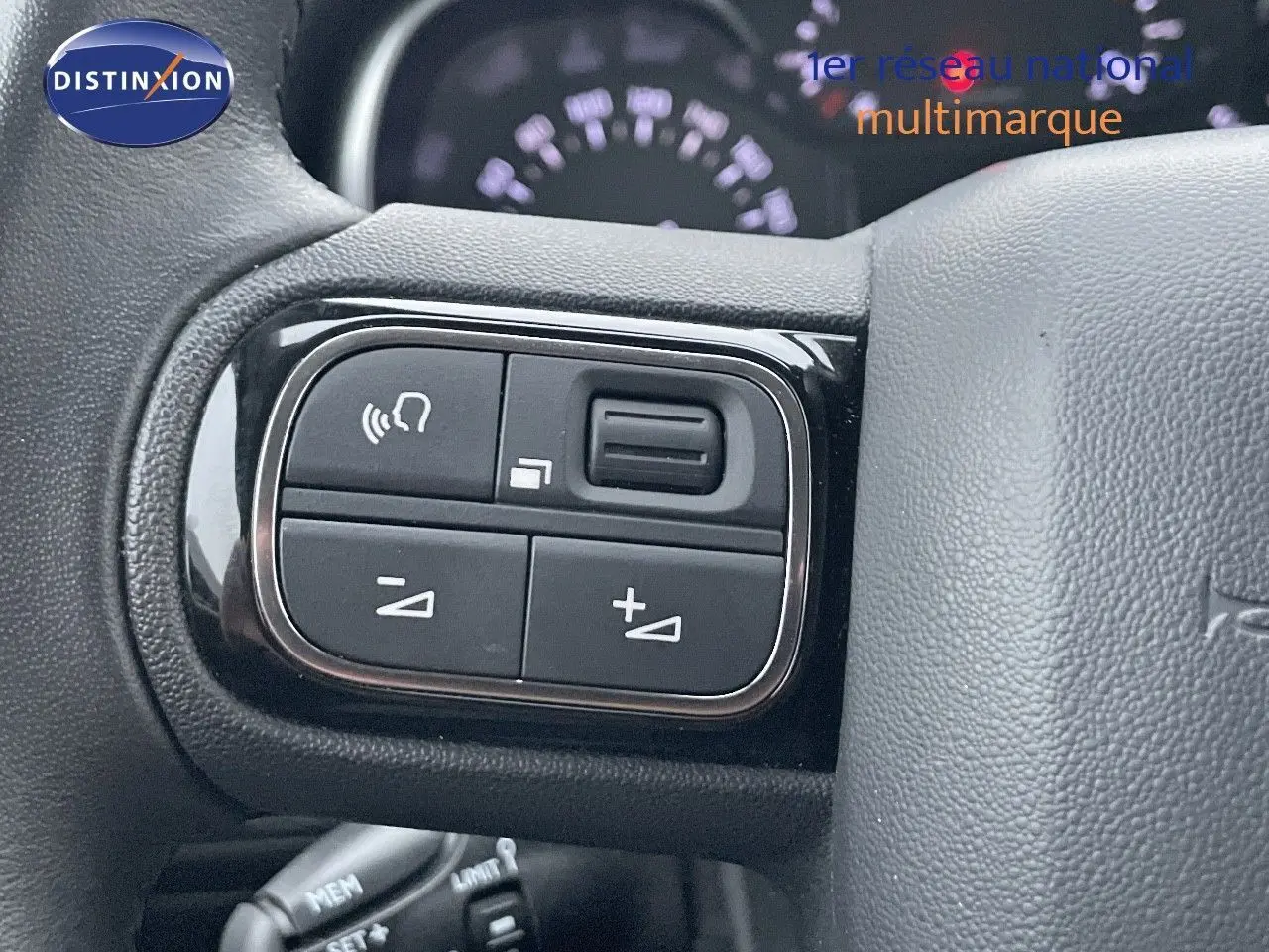 Gros plan sur les commandes de volume et téléphone intégrées au volant du Citroën C3 Aircross gris platinium 2023.