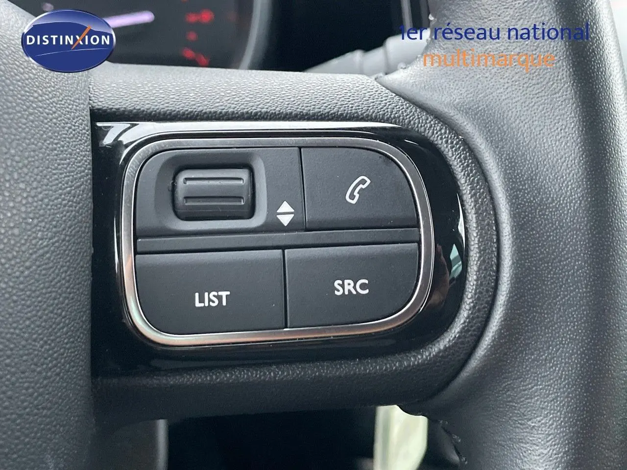Gros plan sur les commandes au volant du Citroën C3 Aircross 2023, finition Shine, en tissu gris noir.
