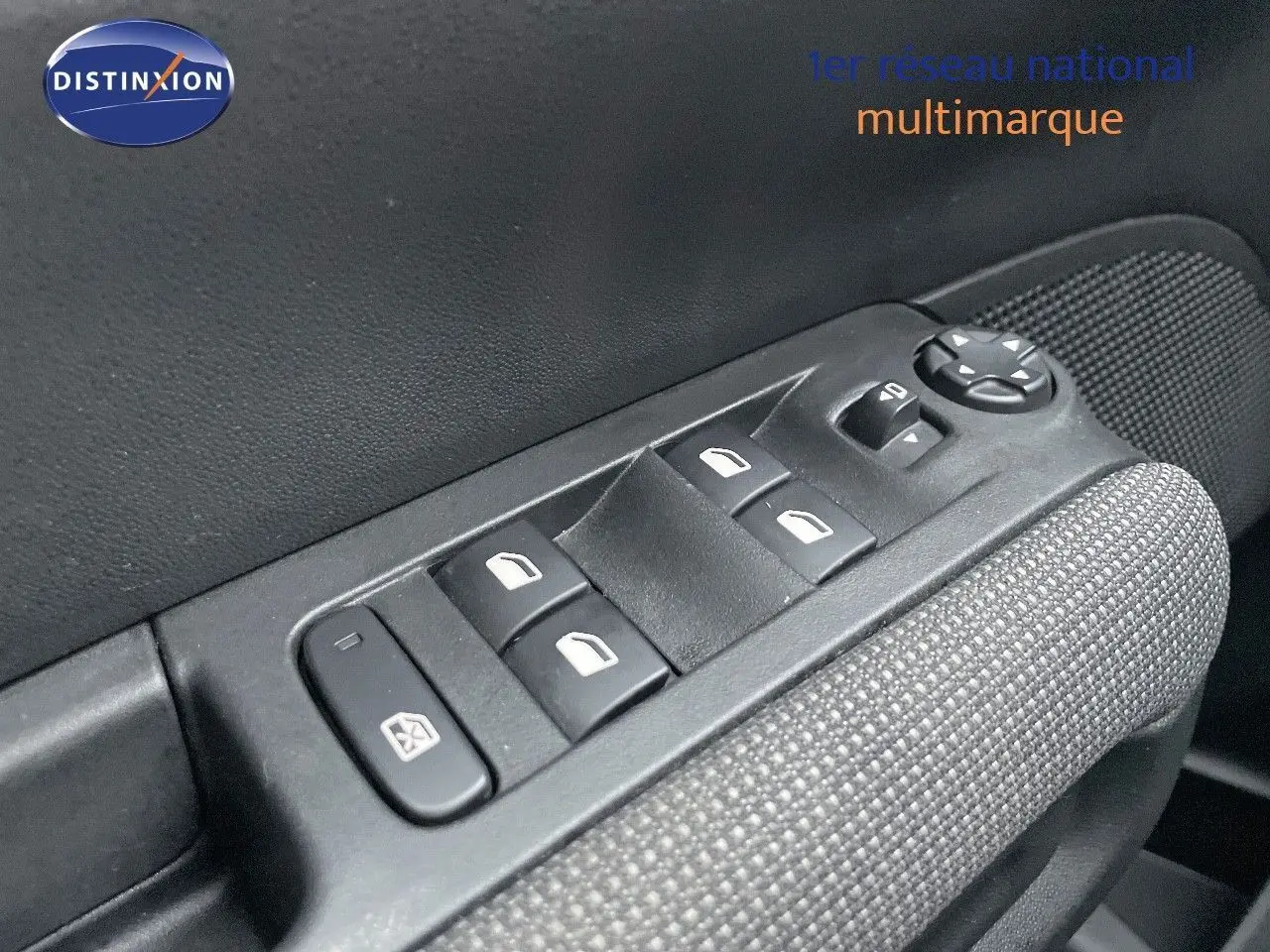 Gros plan sur les commandes des vitres électriques et réglage des rétroviseurs côté conducteur du Citroën C3 Aircross gris platinium 2023.