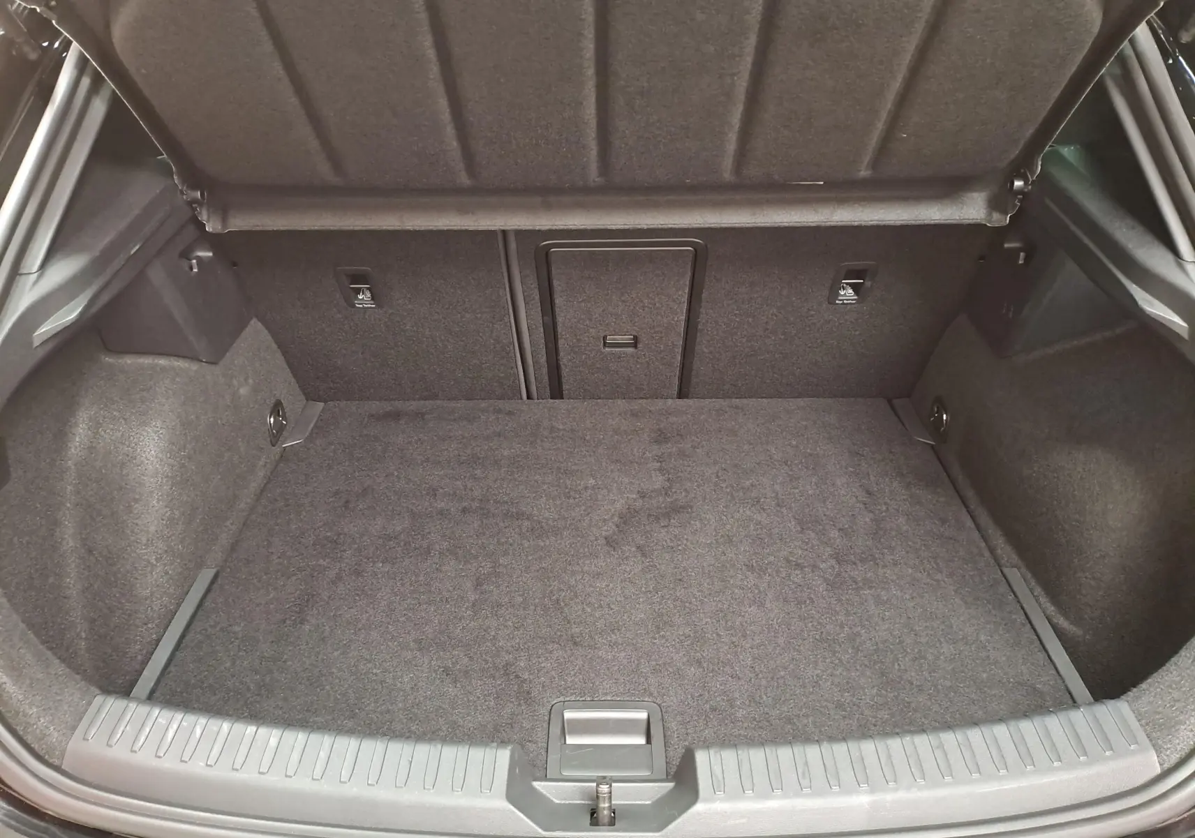 Coffre ouvert vu de l'arrière d'une CUPRA Leon Ph.2 Noir Minuit, montrant un espace de chargement propre et spacieux.