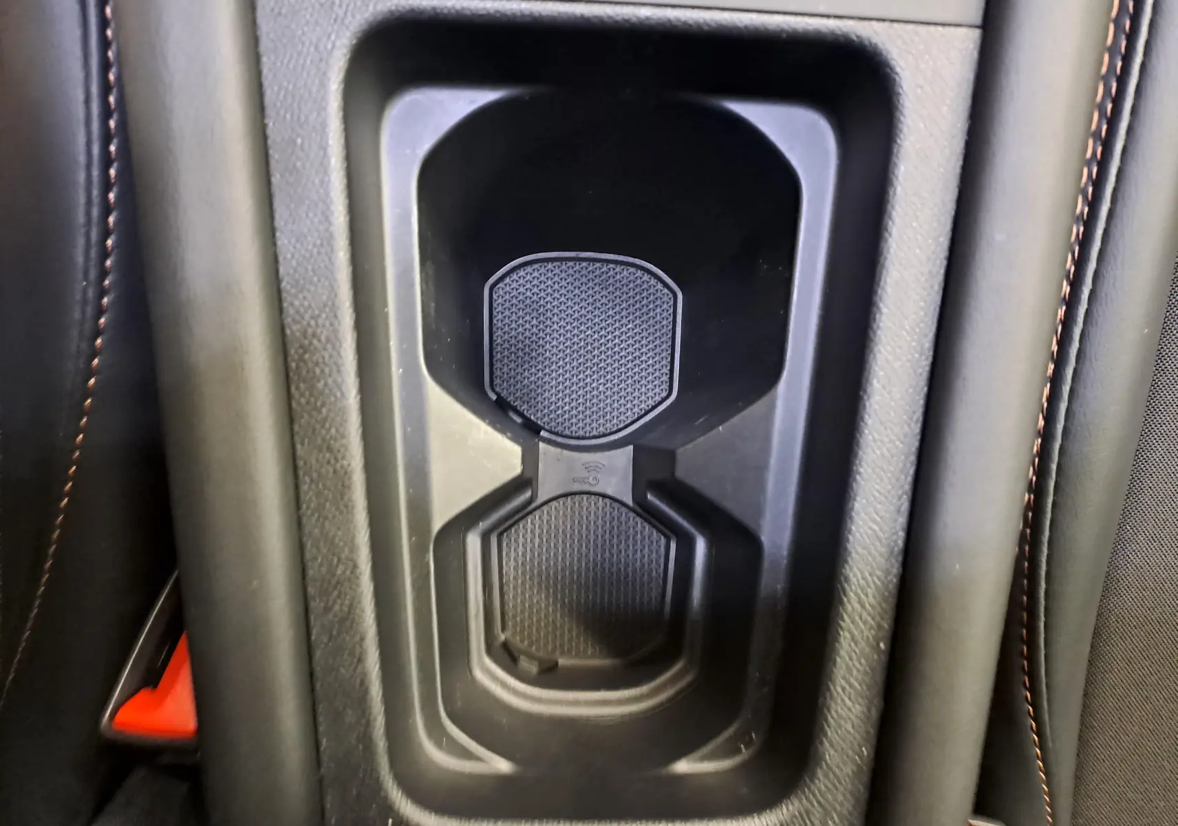 Gros plan sur le porte-gobelets central avec surpiqûres cuivrées dans l'habitacle noir du CUPRA Leon 2025.