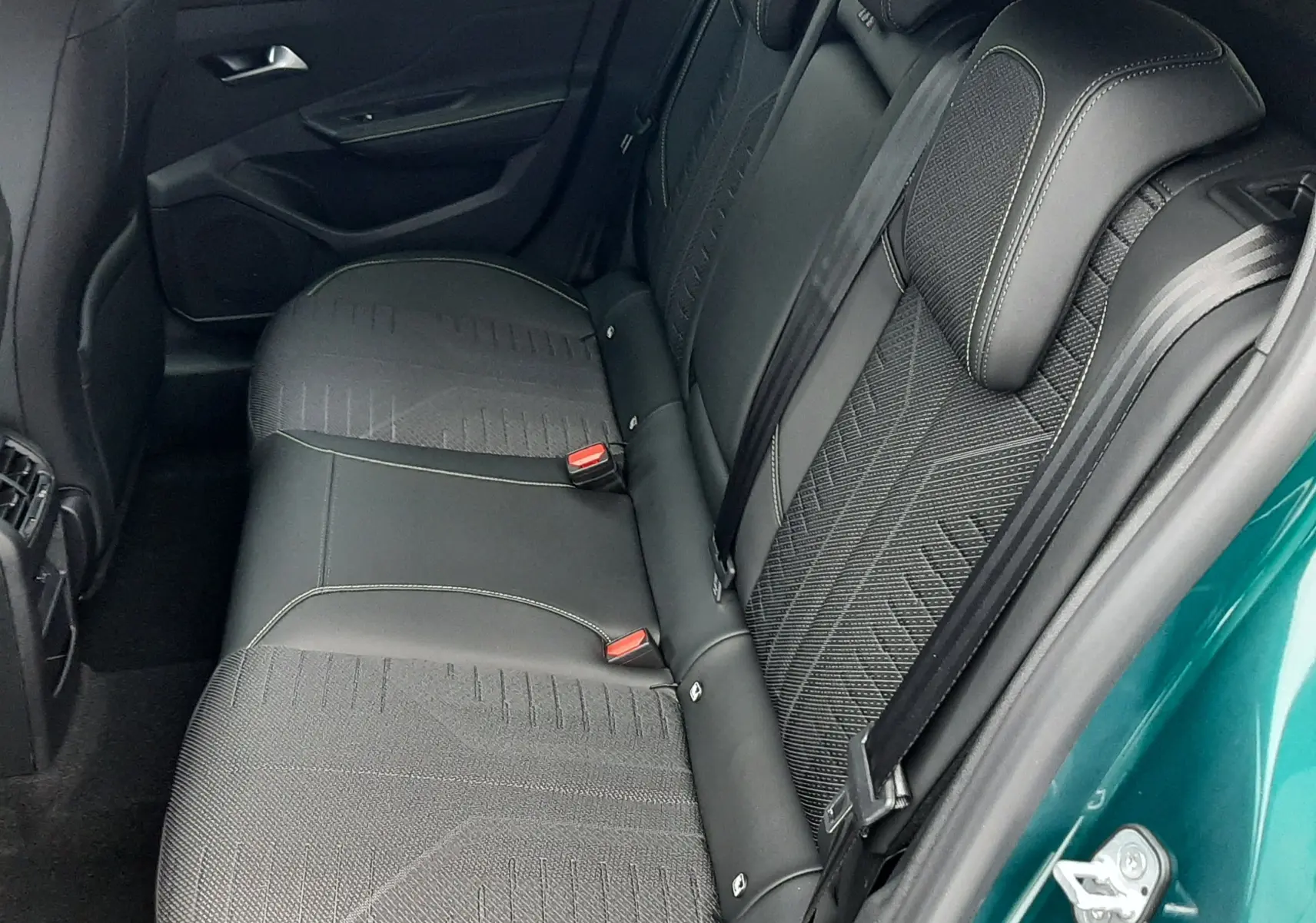 Vue intérieure côté droit des sièges arrière en tissu et cuir noir d'une Peugeot 308 bleu Lagoa 2026.