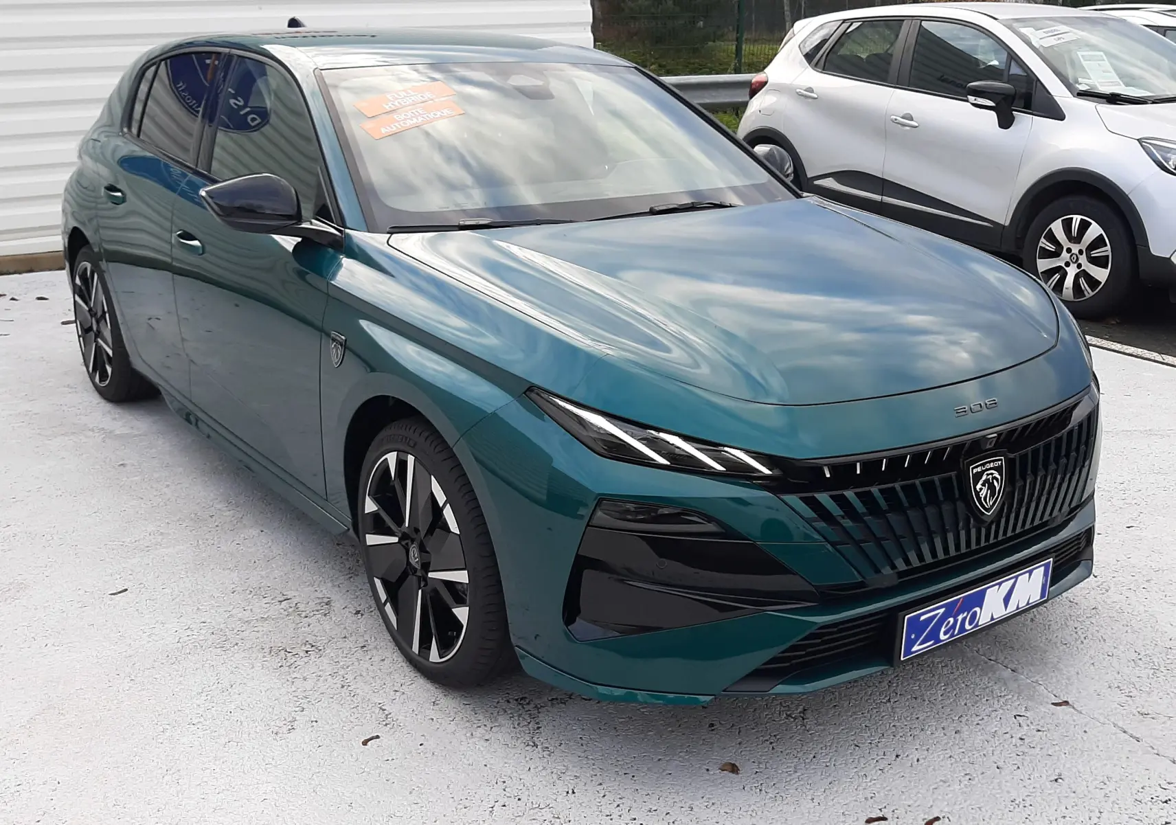 Peugeot 308 1.2 Hybrid 145ch GT bleu Lagoa vue 3/4 avant avec calandre noire et jantes bi-ton.