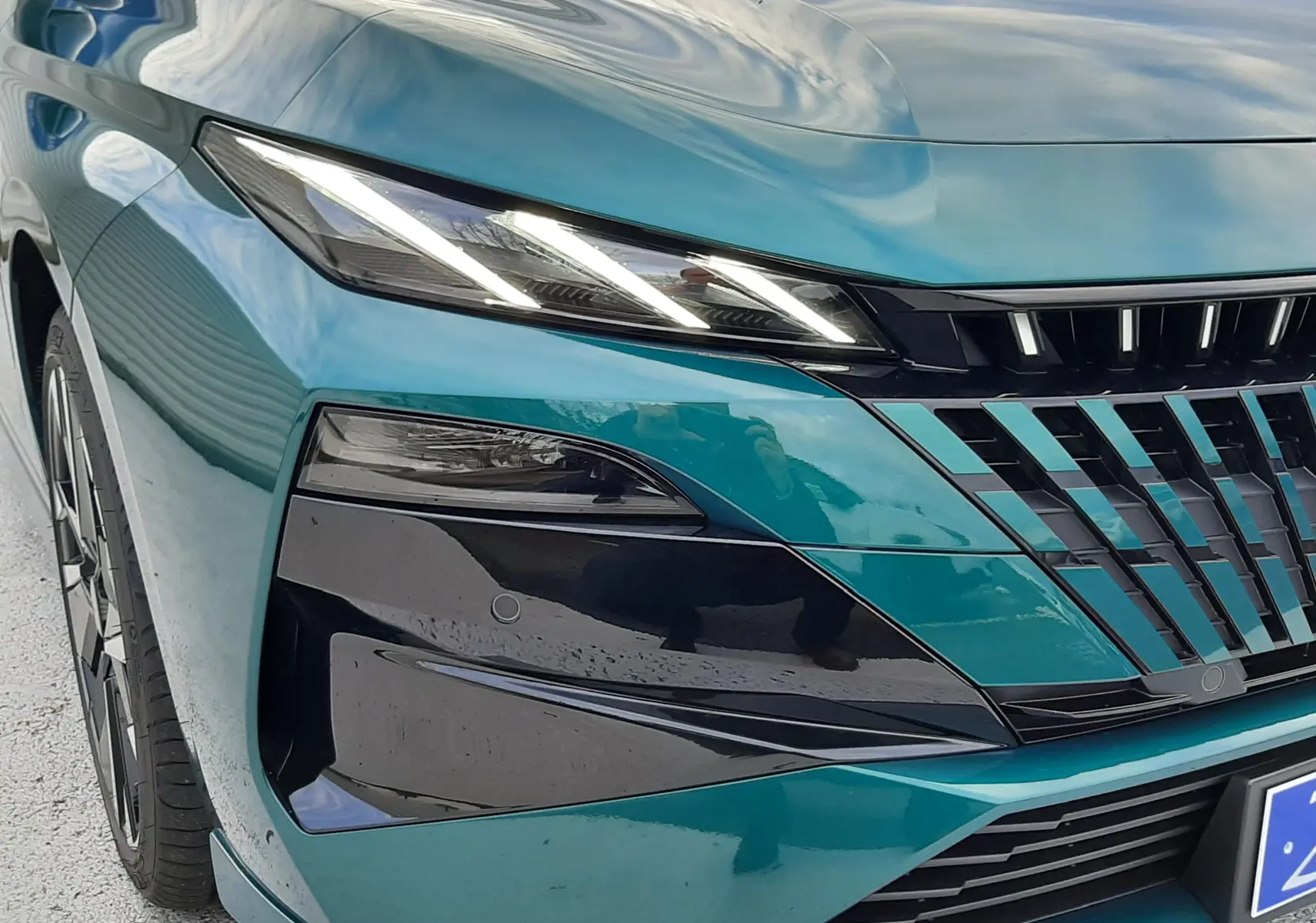 Vue 3/4 avant gauche d'une Peugeot 308 bleu Lagoa, mettant en valeur ses phares LED et la calandre noire distinctive.