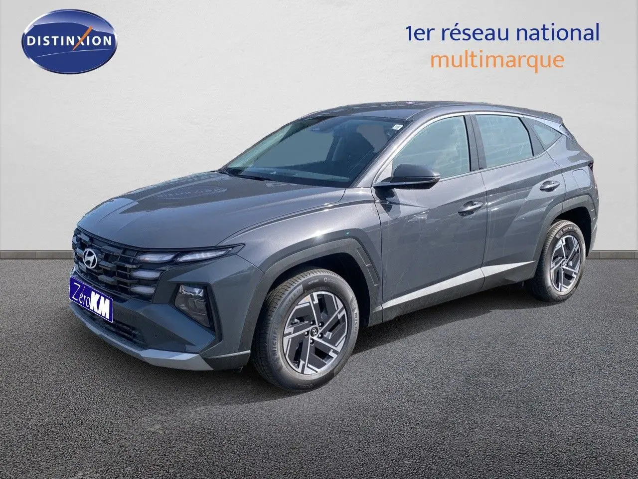 Vue 3/4 avant droit du Hyundai Tucson gris Ecotronic Metal avec calandre distinctive et jantes bi-ton.