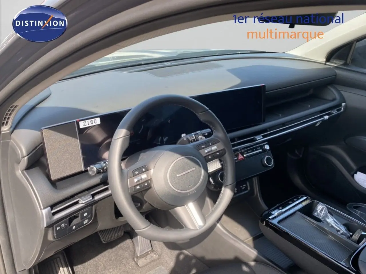 Vue intérieure de face du tableau de bord et du volant noir du Hyundai Tucson 2026, avec écran tactile large et finition moderne.