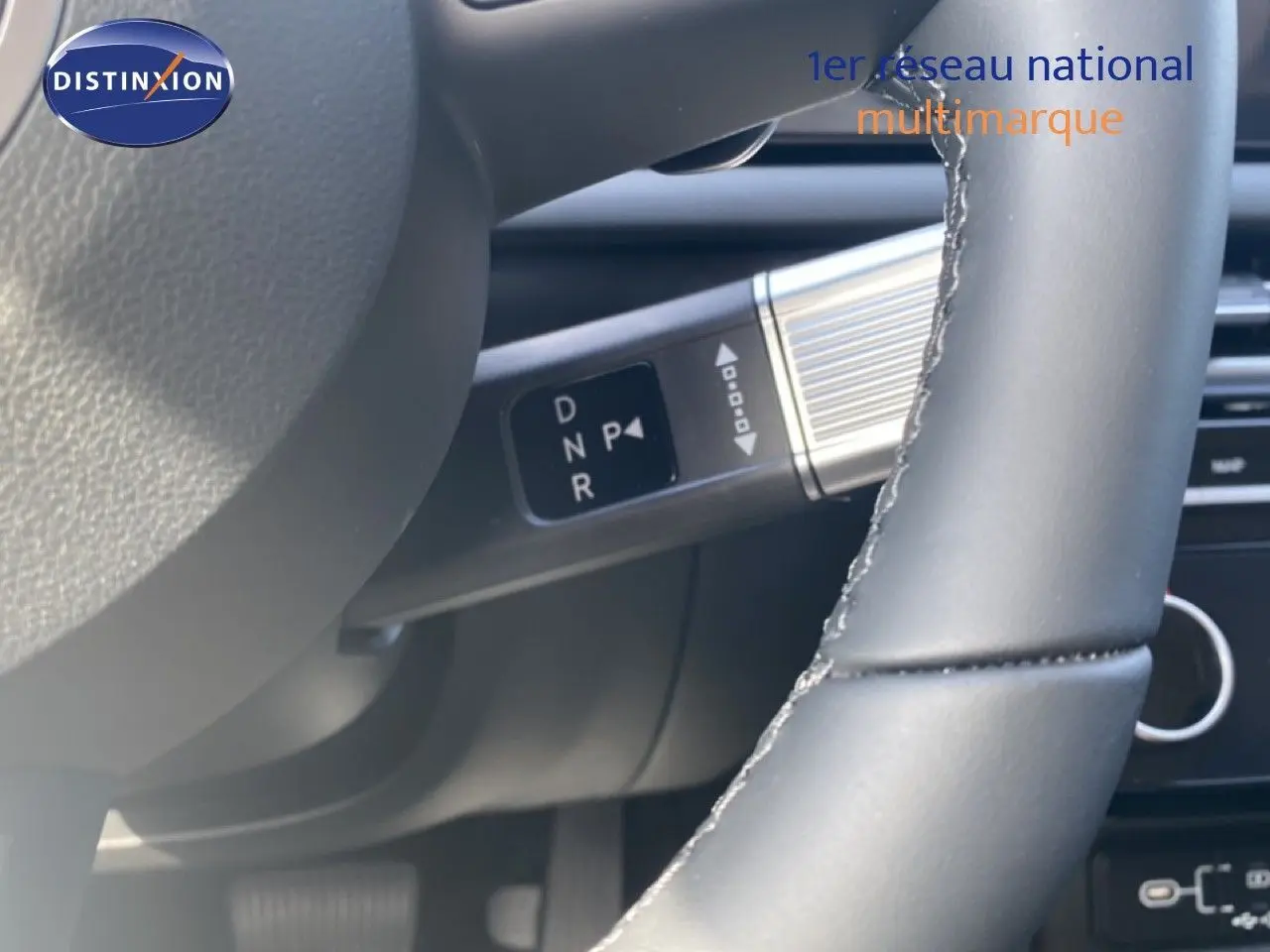 Gros plan sur le volant gris cuir et la commande de boîte automatique du Hyundai Tucson 2026 hybride.