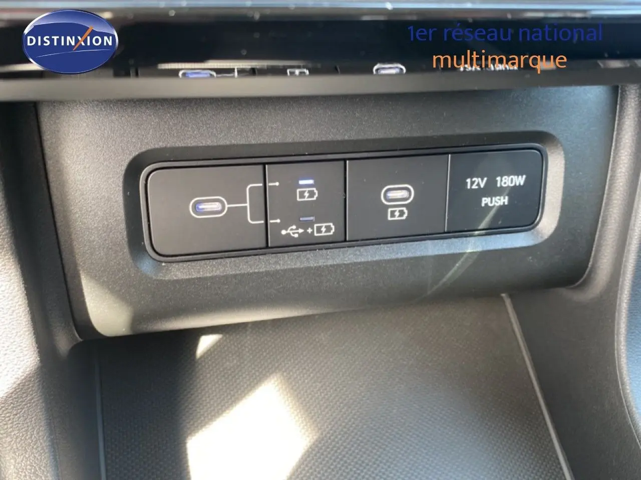Gros plan sur les ports USB et prise 12V du Hyundai Tucson gris Ecotronic 2026, côté console centrale.
