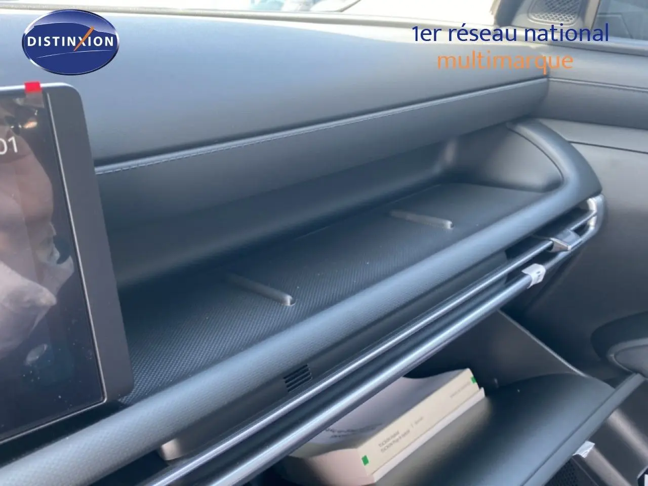 Détail de la planche de bord noire du Hyundai Tucson 2026, avec tablette tactile partiellement visible côté gauche.
