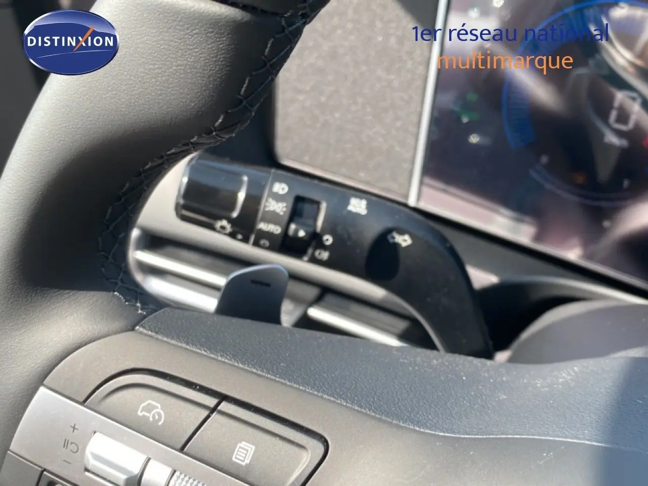 Gros plan sur le volant noir et les commandes intégrées du Hyundai Tucson 2026, version hybride gris Ecotronic Metal.