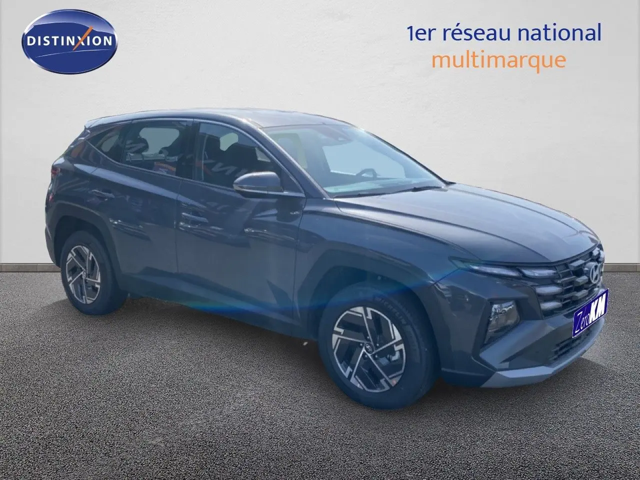 Hyundai Tucson 2026 gris Ecotronic Metal en 3/4 avant droit, avec jantes alliage et calandre distinctive.