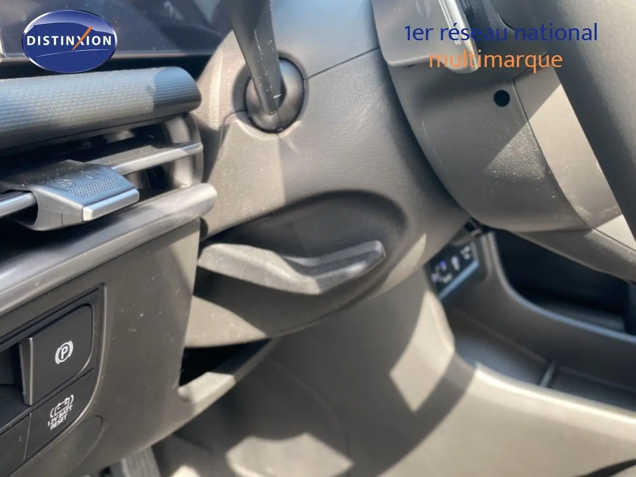 Détail intérieur côté gauche du Hyundai Tucson gris Ecotronic, montrant commandes de frein à main et partie du tableau de bord.