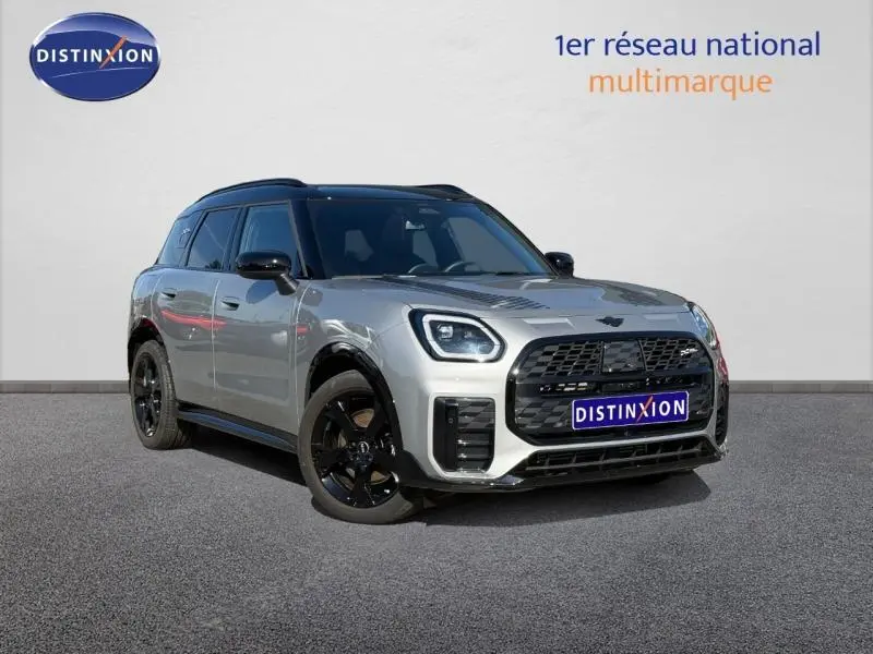 Vue 3/4 avant d'un MINI Countryman C 170ch JCW DKG7 argenté avec jantes noires sur fond neutre.