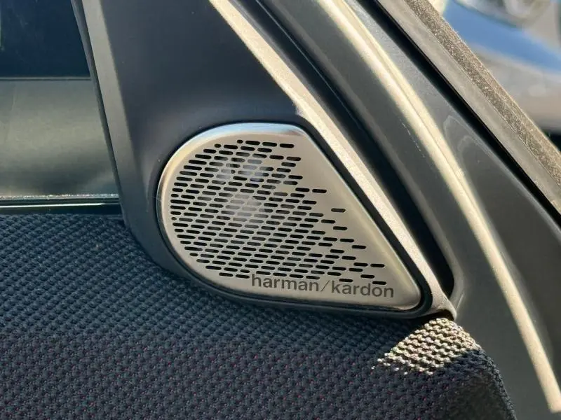Gros plan sur le haut-parleur Harman Kardon intégré dans la garniture intérieure noire d'une MINI Countryman argentée.