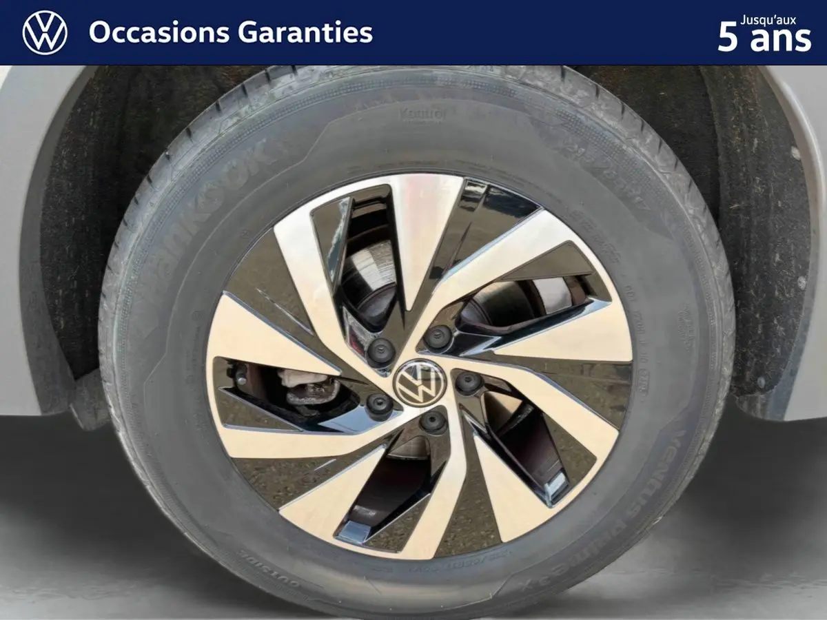 Gros plan sur la jante alliage Venezia noire et brillante du Volkswagen Tiguan gris, mettant en valeur son design moderne.