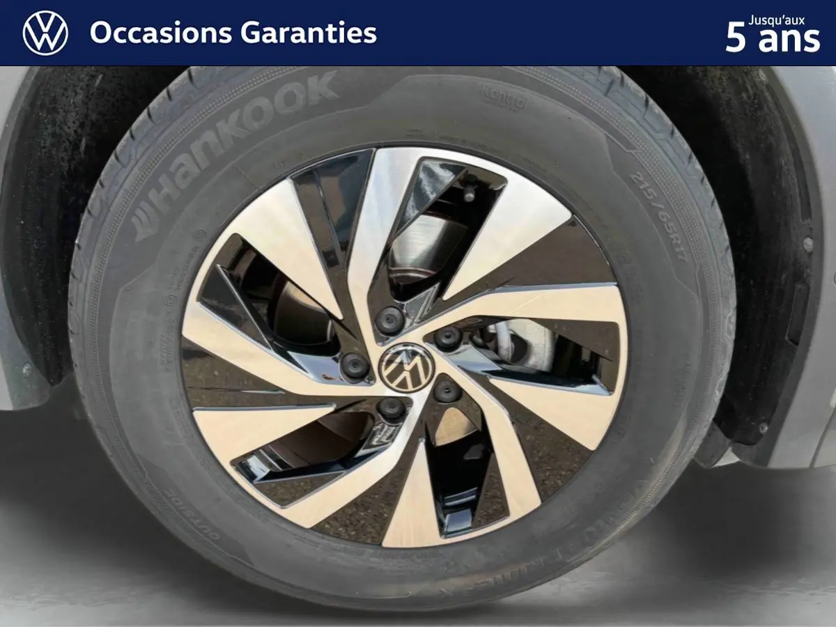 Gros plan sur la jante alliage Venezia noire et brillante du Volkswagen Tiguan gris, mettant en valeur son design moderne.