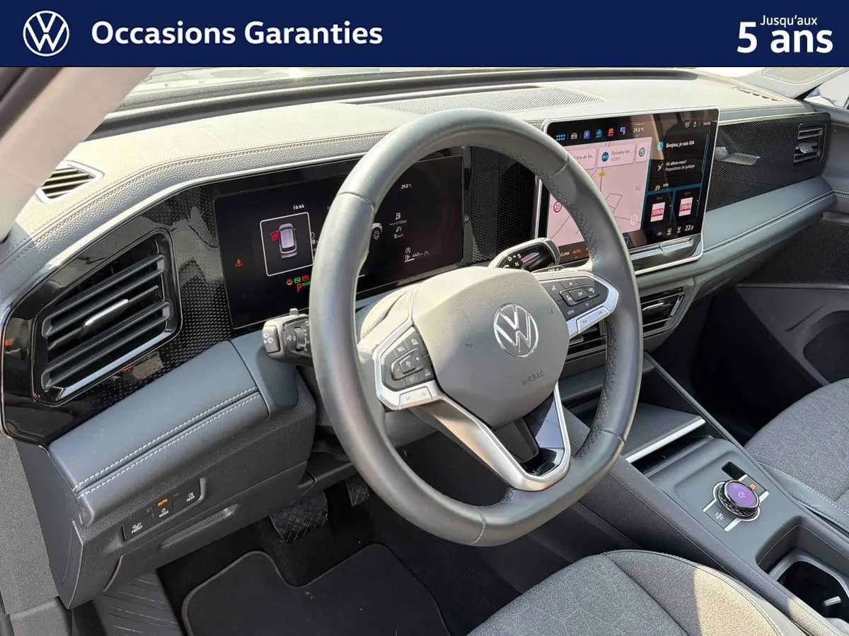 Vue intérieure du tableau de bord et volant cuir du Volkswagen Tiguan 2025 avec écran tactile et finitions grises.