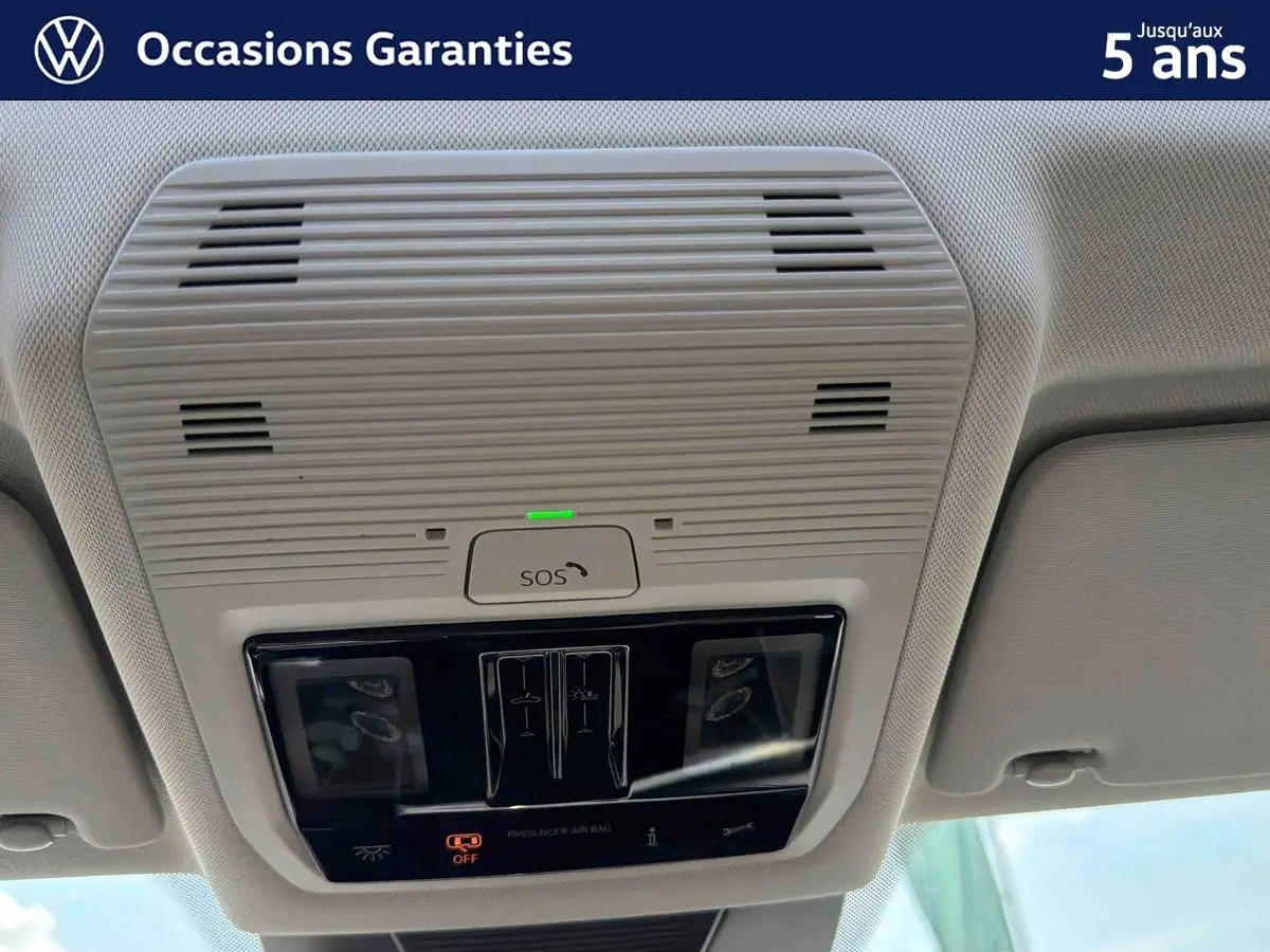 Vue en contre-plongée du plafonnier gris clair avec commandes SOS et éclairage intérieur du Volkswagen Tiguan 2025.