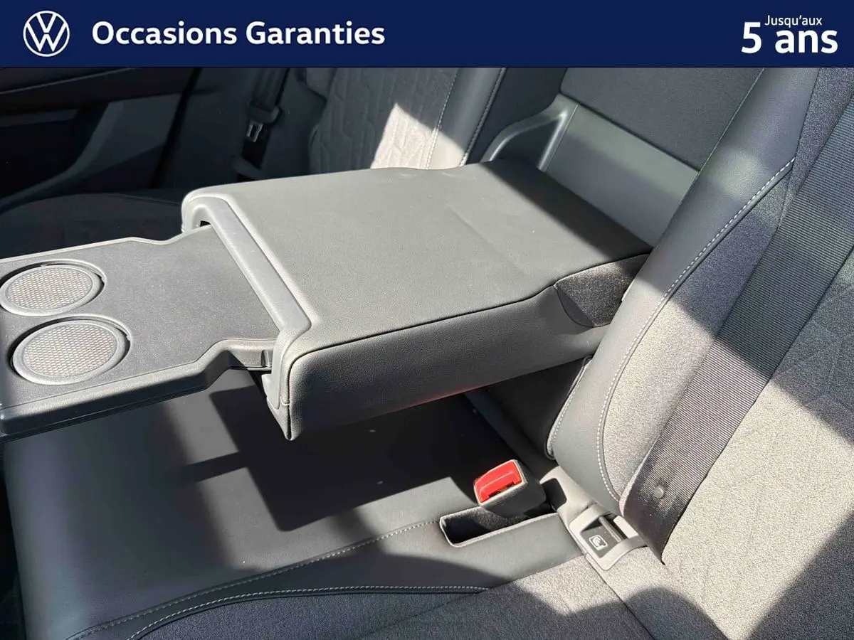 Détail de l'accoudoir central arrière déployé avec porte-gobelets du Volkswagen Tiguan gris, intérieur tissu et cuir.