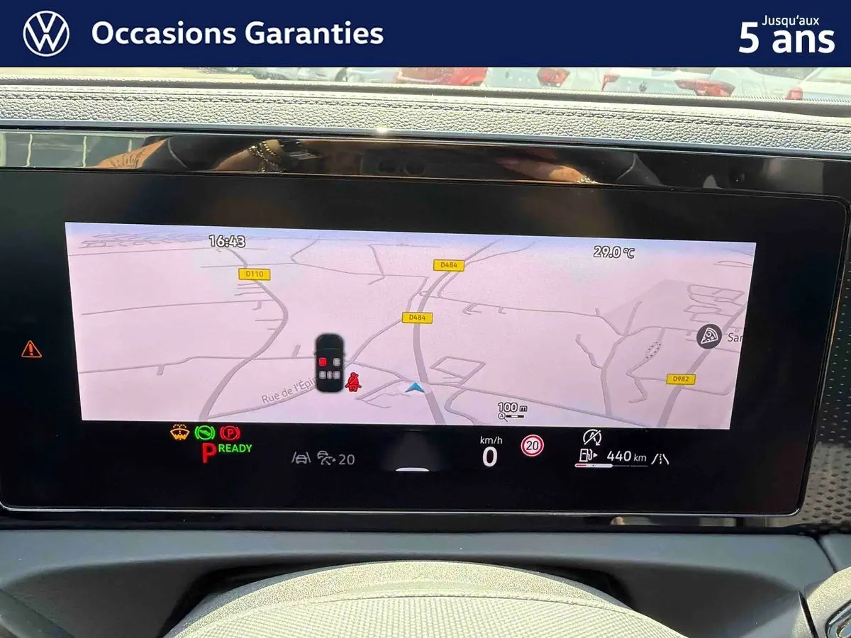 Tableau de bord numérique du Volkswagen Tiguan 2025 affichant la navigation et les alertes, vue intérieure frontale.