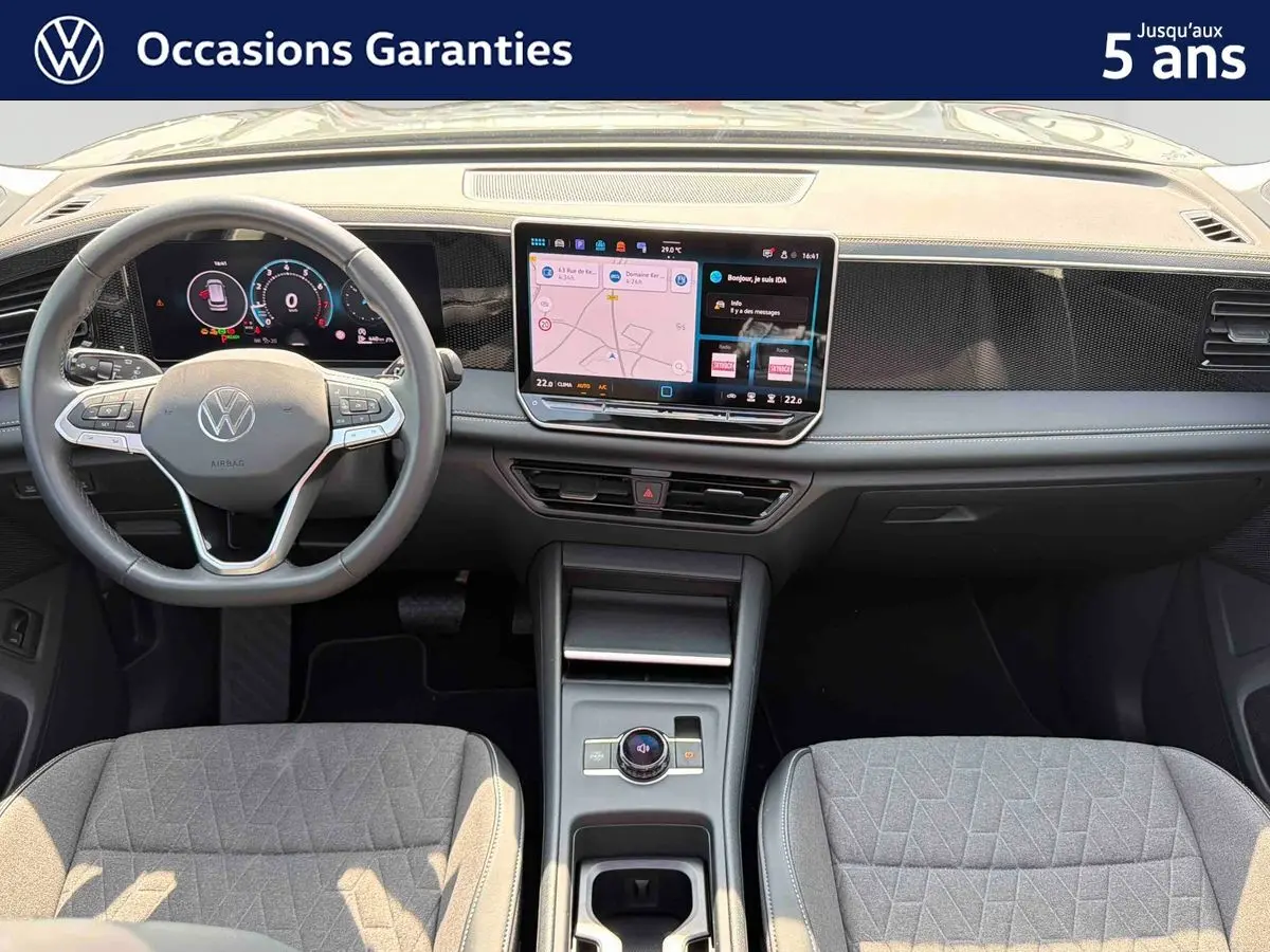 Vue intérieure frontale du Volkswagen Tiguan 2025 gris, avec tableau de bord digital et écran tactile central.