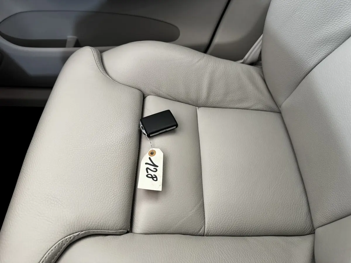 Gros plan sur le siège avant droit en cuir beige clair avec clé noire et étiquette dans l'habitacle d'un Volvo XC60.