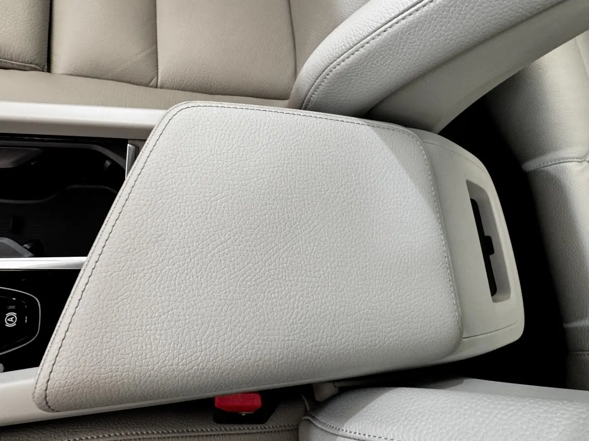 Détail de l'accoudoir central en cuir beige clair du Volvo XC60 Recharge T8 2021, avec console et bouton frein à main visible.