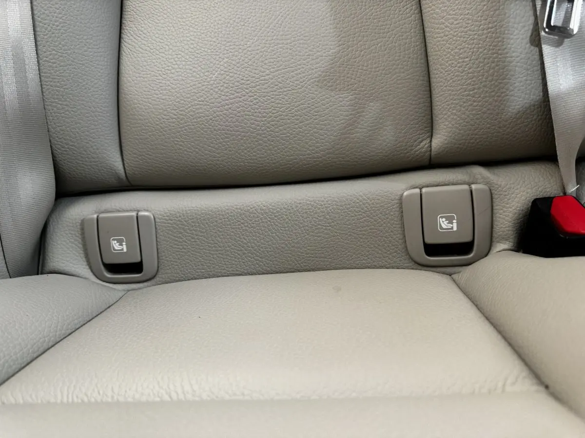 Détail des fixations ISOFIX sur la banquette arrière en cuir beige du Volvo XC60 bleu hybride rechargeable.