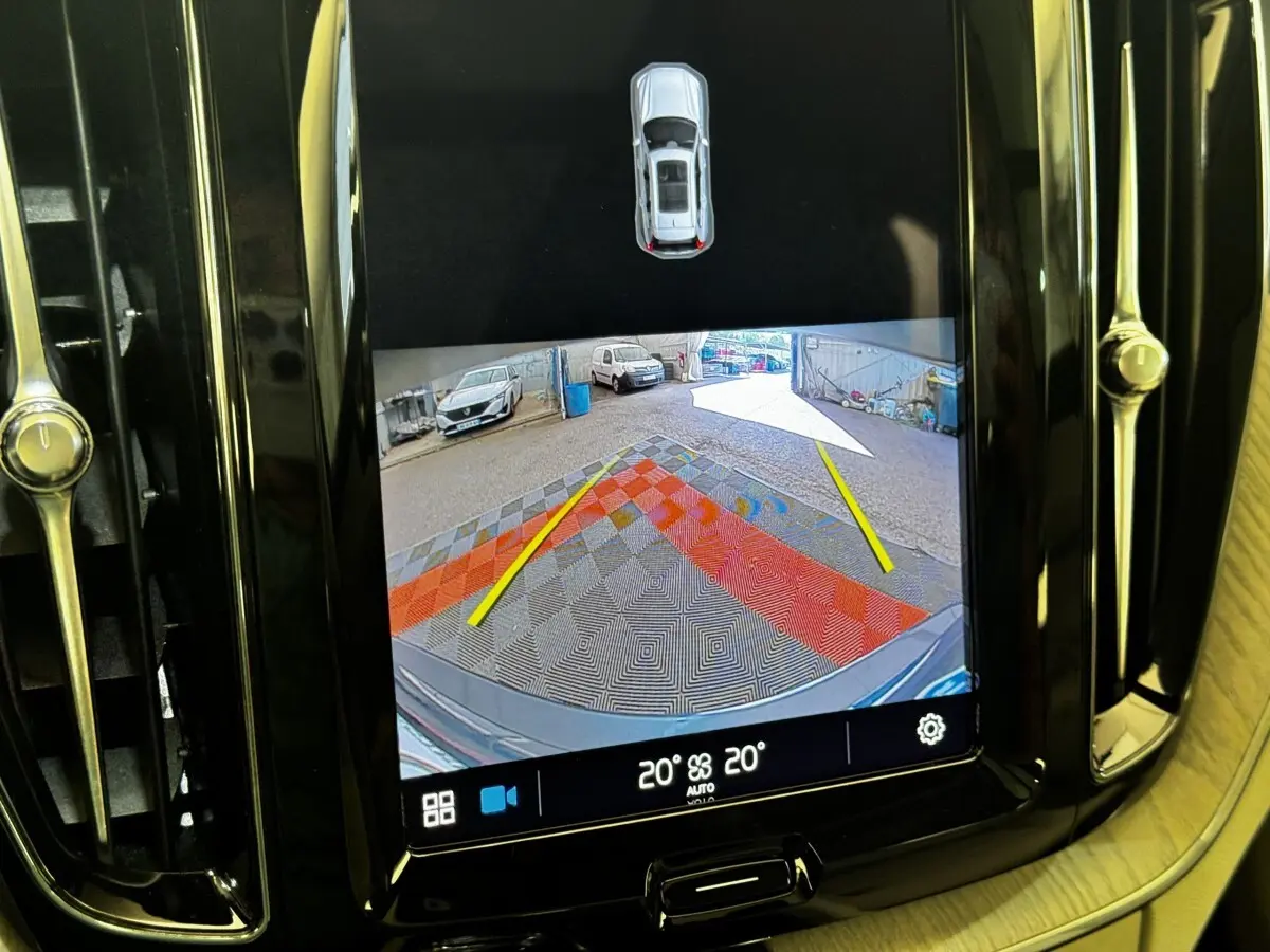 Écran tactile intérieur montrant la caméra de recul avec vue arrière et repères jaunes du Volvo XC60 bleu.