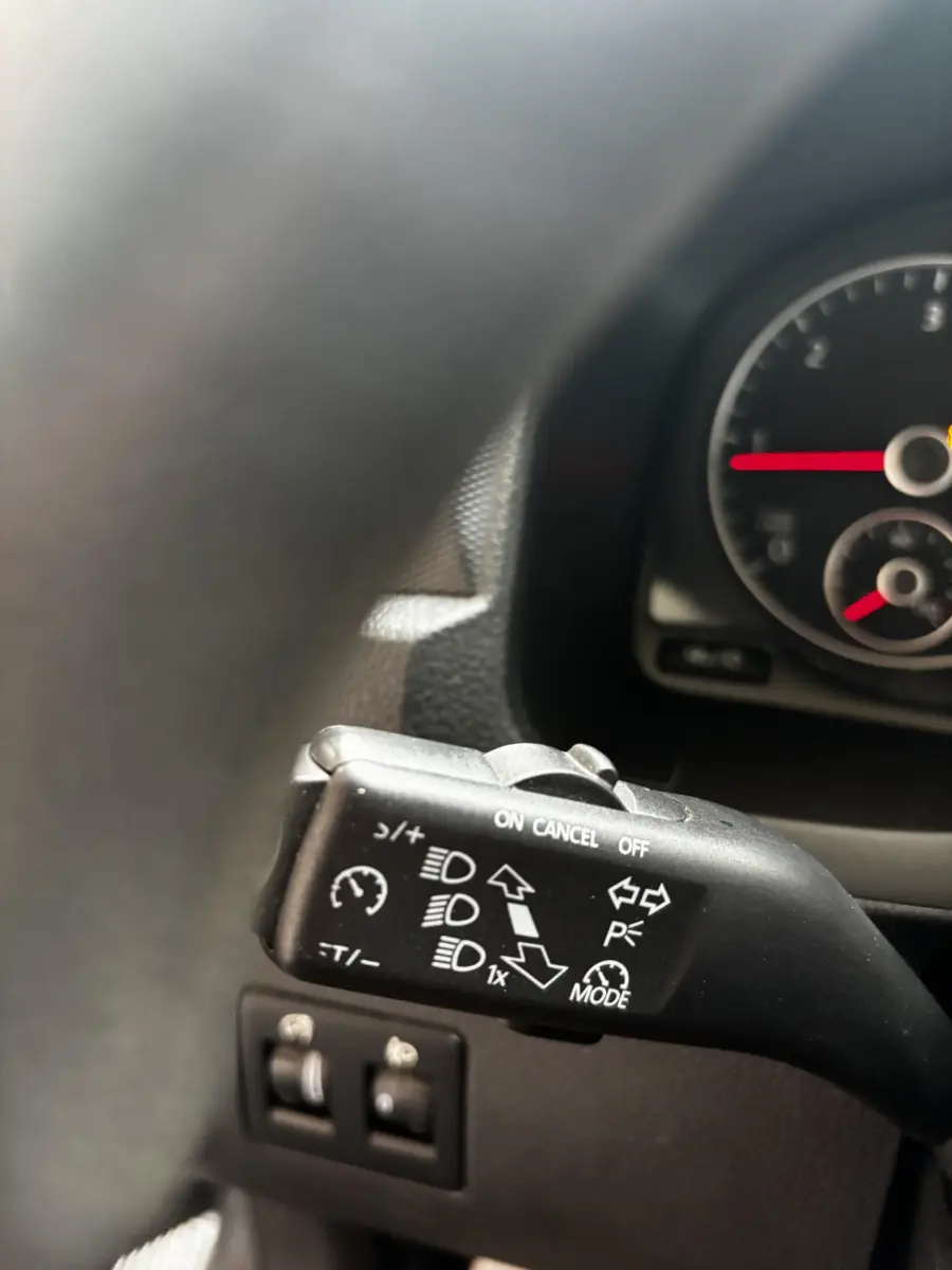 Gros plan sur la commande de régulateur de vitesse et phares dans l'habitacle du Volkswagen Caddy gris foncé 2019.