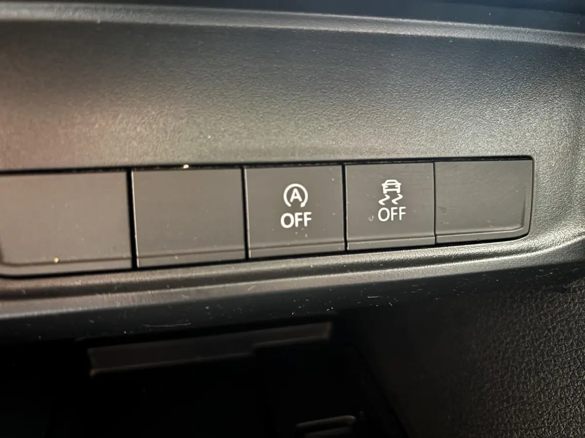 Gros plan sur les boutons de désactivation du système start-stop et de l'antipatinage du Volkswagen Caddy gris foncé 2019.