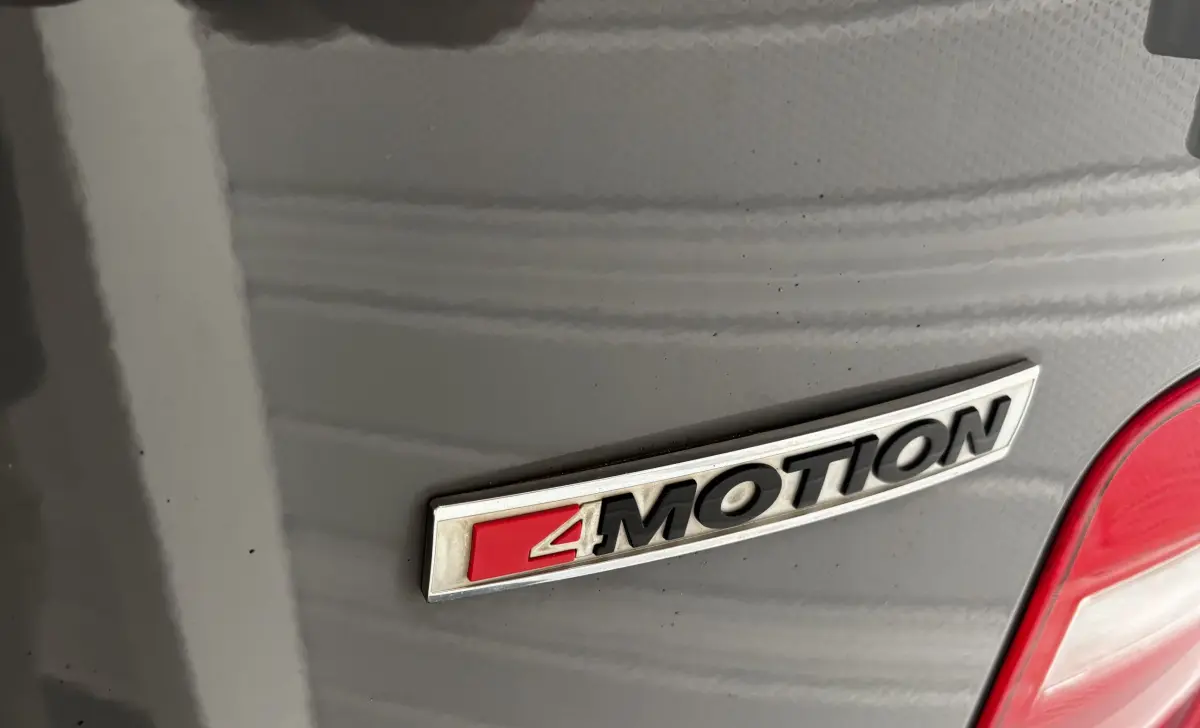 Gros plan sur l'emblème 4MOTION gris foncé à l'arrière droit du Volkswagen Caddy 2019.