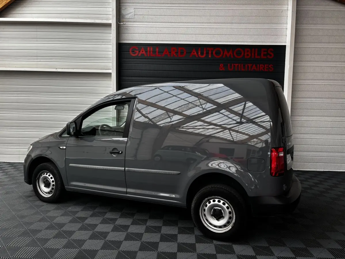 Profil côté gauche d'un utilitaire Volkswagen Caddy gris foncé 2019 avec jantes acier et carrosserie lisse sans vitres arrière.